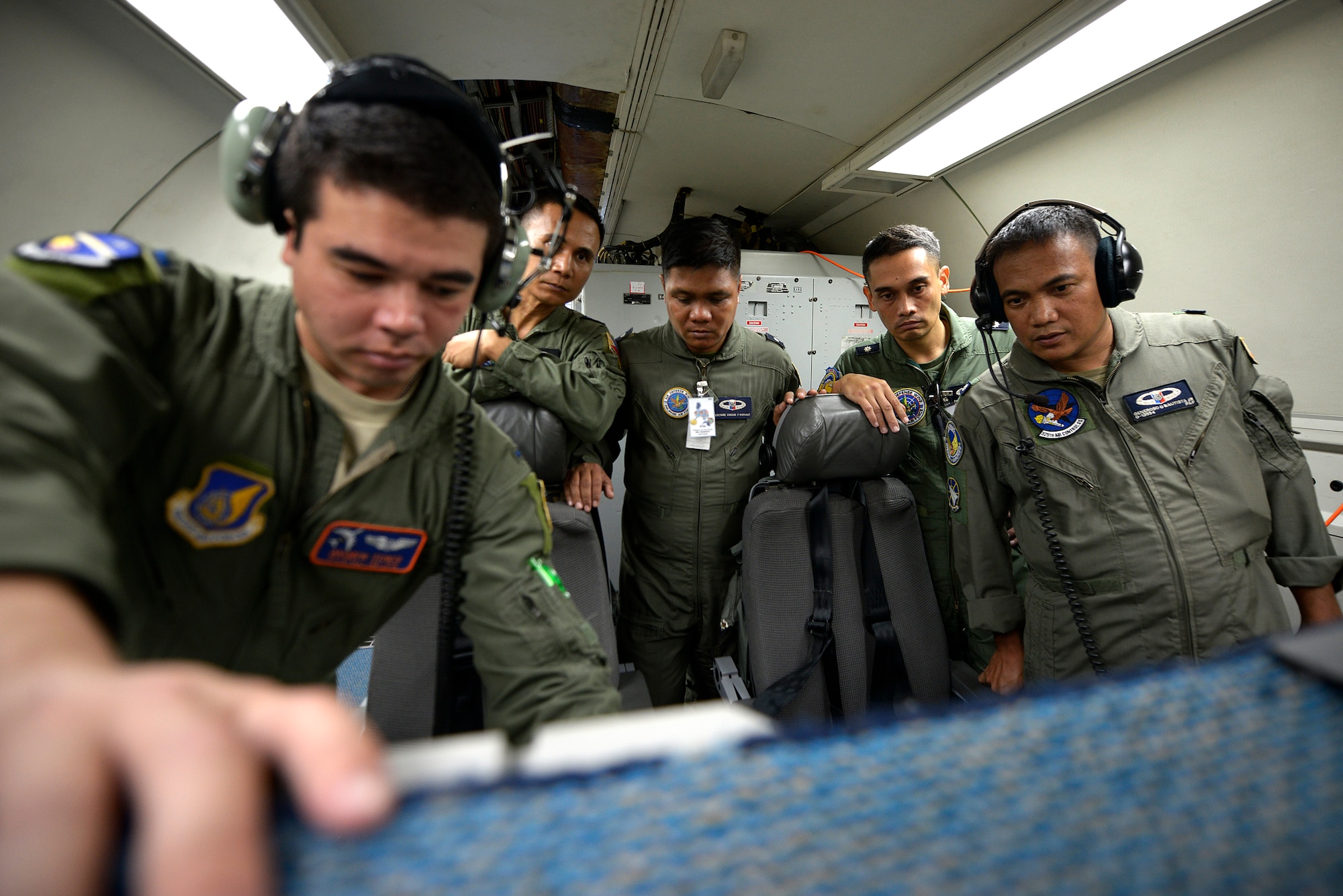 U.S. Air Force 1st Lt. Andrew Stokes, 961st Airborne Air Control Squadron (AACS) air weapons officer, demonstrates weapons systems operations with Philippines Air Force weapons controllers while onboard a 961st AACS E-3 Sentry Airborne Warning and Control System aircraft during Exercise Balikatan 2015 over the Philippines, April 23. This exercise marks the first time in history that PAF air battle managers have controlled other aircraft while onboard the AWACS. Since the exercise began, April 20, the 961st AACS has integrated 20 PAF weapons controllers during their missions to provide them with first-hand experience using the aircraft’s systems. The 961st AACS is stationed at Kadena Air Base, Japan. (U.S. Air Force photo by Staff Sgt. Maeson L. Elleman)