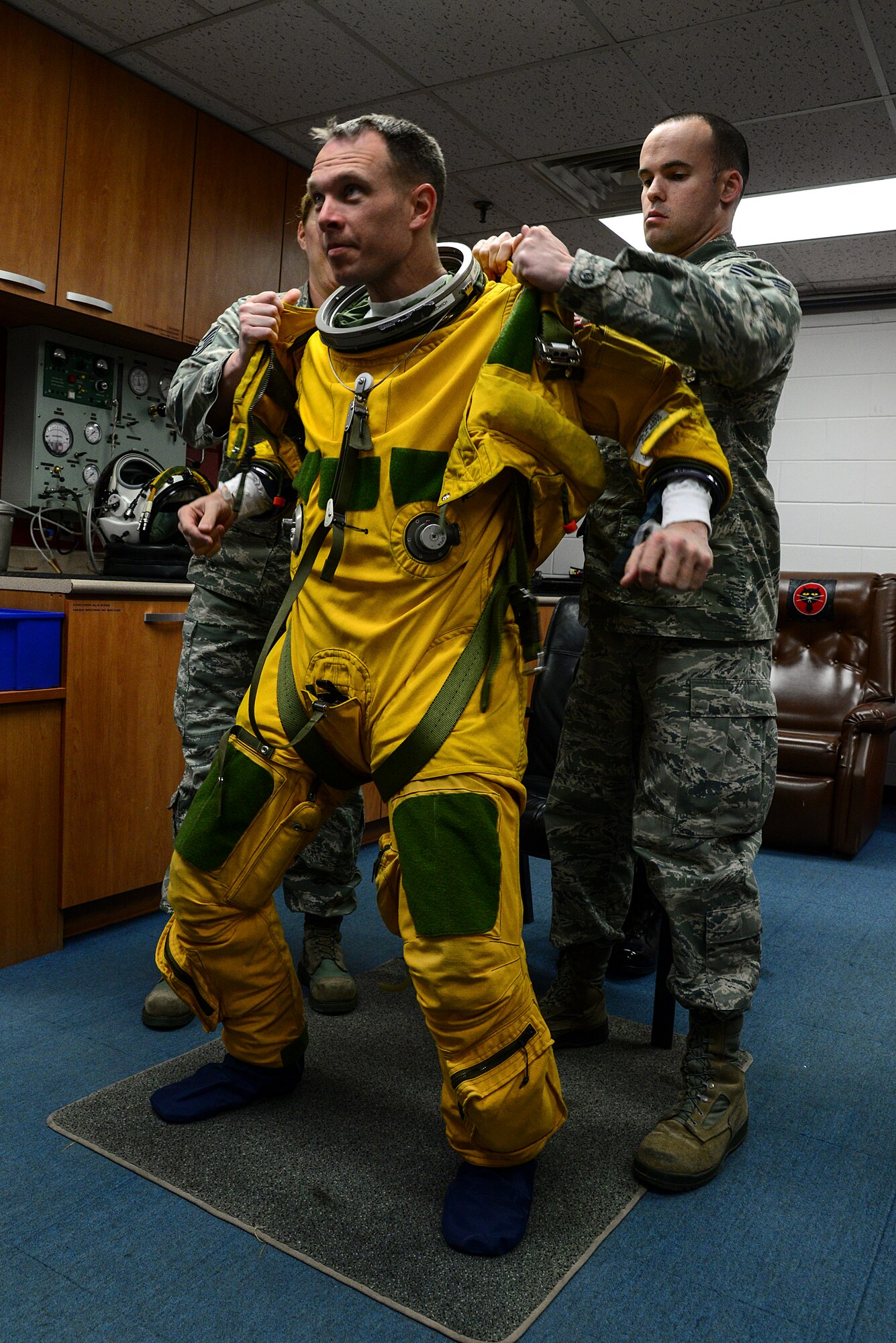 Staff Sgt. Stacy Klein and Staff Sgt. Joseph Kennedy, 5th Reconnaissance Squadron physiological technicians, assisit Lt. Col. Luke Lokowich, 5th RS commander and a U-2 pilot, with his high-altitude pressure suit April 22, 2015, at Osan Air Base, Republic of Korea. A pressure suit is a protective suit worn by pilots who may fly at altitudes where the air pressure is too low for an unprotected person to survive. (U.S. Air Force photo by Senior Airman Matthew Lancaster)