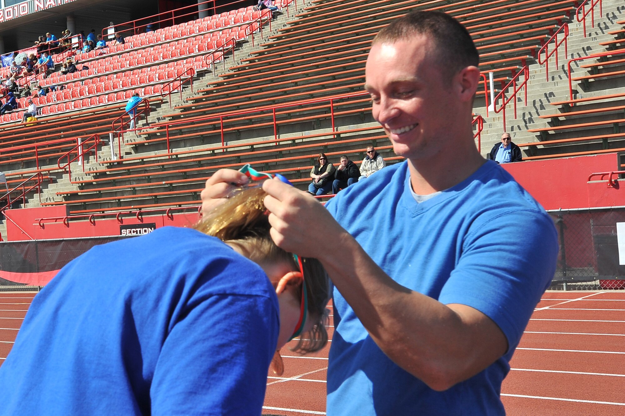 Airman 1st Class Kyle Henshaw, 92nd Civil Engineer Squadron power pro specialist, places a medal on a winning participant during the Spring Special Olympics May 2, 2015, in Cheney, Wash. The Special Olympics games were founded in 1968, and are held throughout the U.S. annually. (U.S. Air Force photo/Staff Sgt. Veronica Montes)