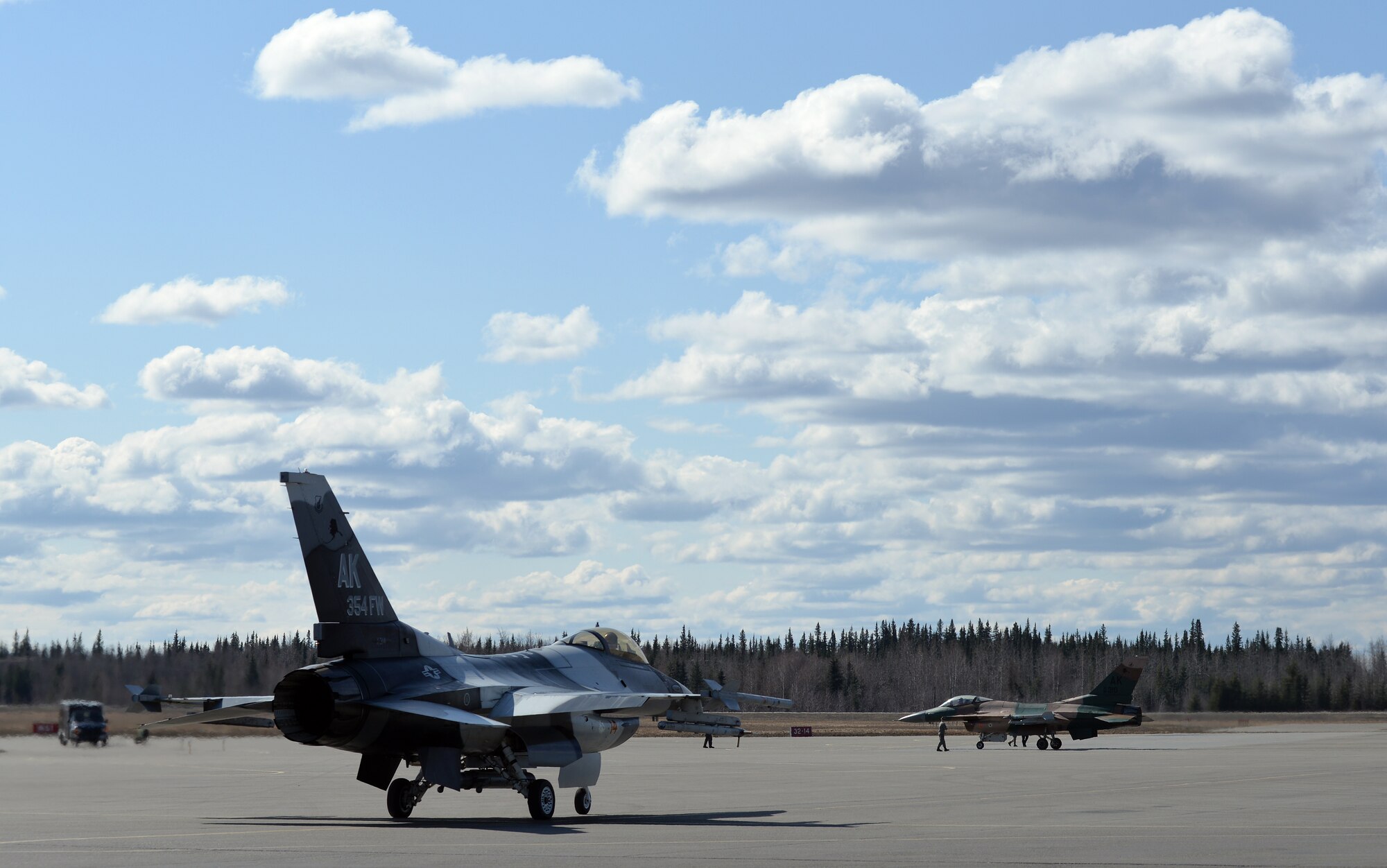 U.S. Air Force F-16 Fighting Falcon aircraft assigned to the 18th Aggressor Squadron taxi to the Eielson Air Force Base, Alaska, runway April 27, 2015, to participate in a Distant Frontier mission with F-16 pilots and aircraft deployed from the 113th Wing, District of Columbia Air National Guard. Distant Frontier provided the deployed pilots an opportunity to fly orientation flights in the more than 67,000 square-mile Joint Pacific Alaska Range Complex, become familiar with local flying restrictions, receive local safety and survival briefings, and develop orientation plans during the week prior to RED FLAG-Alaska 15-2, a Pacific Air Forces-directed field training exercise flown under simulated air combat conditions to increases combat capability. (U.S. Air Force photo by Master Sgt. Karen J. Tomasik/Released)