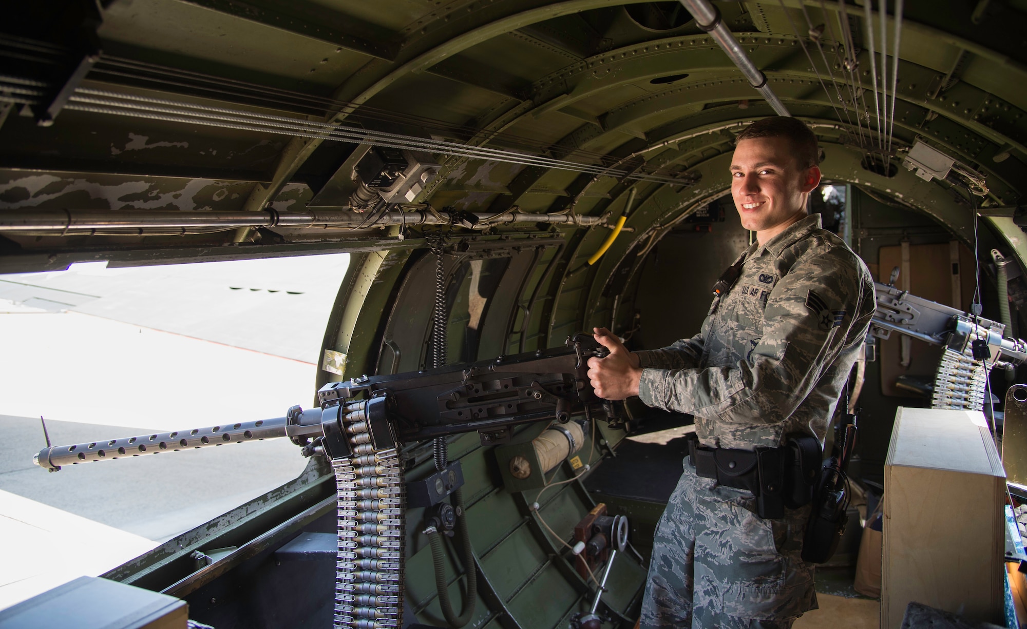 Senior Airman Killia Isbull, 11th Security Forces Squadron patrolman, stands with repurposed Browning .50 caliber M-2 machine gun inside the B-17G Texas Raiders at Joint Base Andrews, Md., May 4, 2015. (U.S. Air Force photo/Airman 1st Class Philip Bryant)