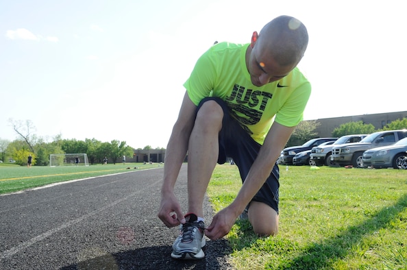 Airman 1st Class Joshua Islas, 11th Wing Staff Agency administrative technician, ties his shoes before a run on Joint Base Andrews Md., May 4, 2015. (U.S. Air Force photo by Senior Airman Mariah Haddenham)