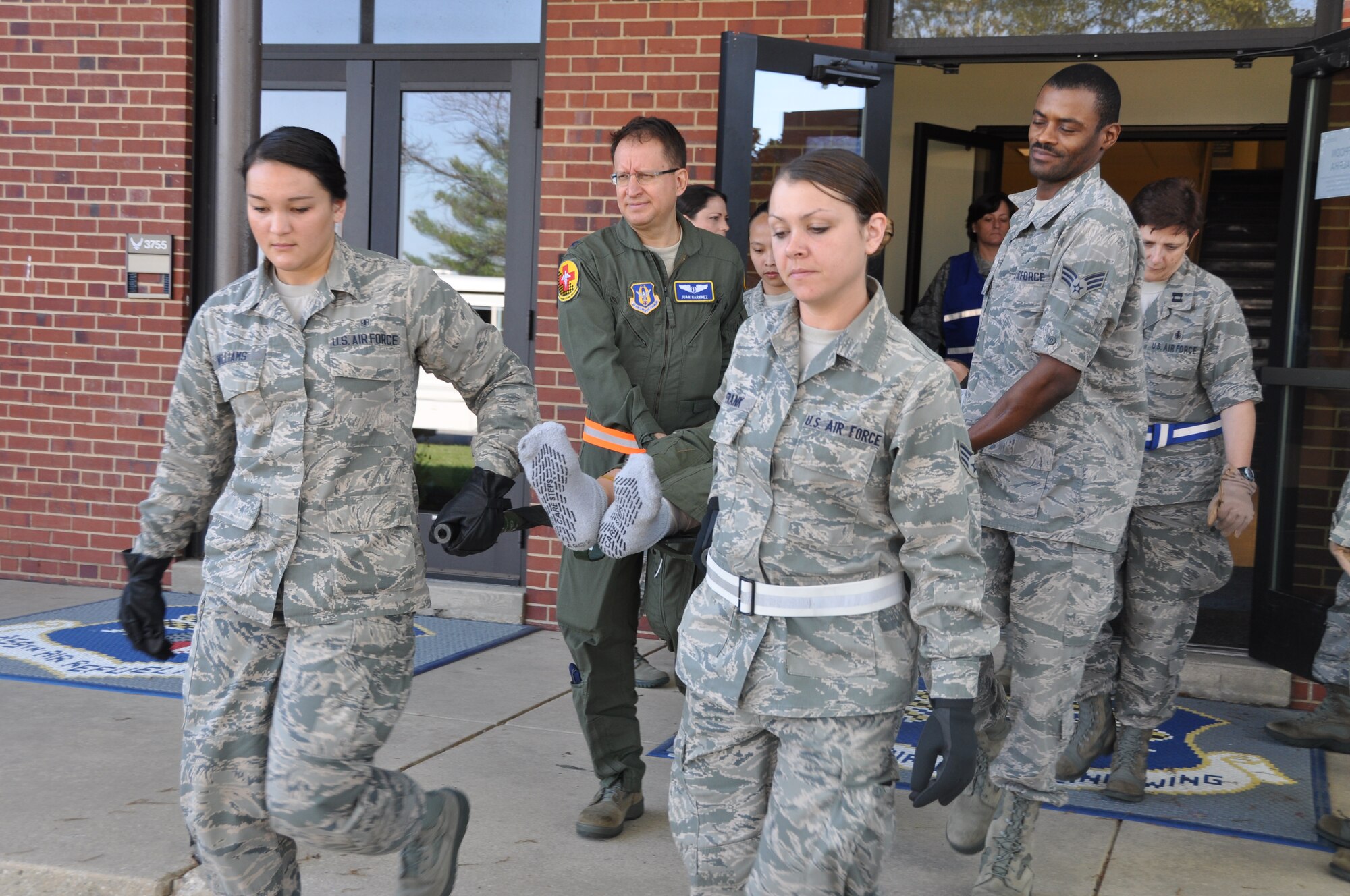Members of the 459th Aeromedical Staging Squadron prepare to load a patient into a bus so that the patient may be transferred to tarmac for an aerial evacuation. The exercise mimicked emergency medical situation in the event of a disaster at Joint Base Andrews on Monday, May 4, 2015 (Air Force Photo / Senior Airman Kristin Kurtz)