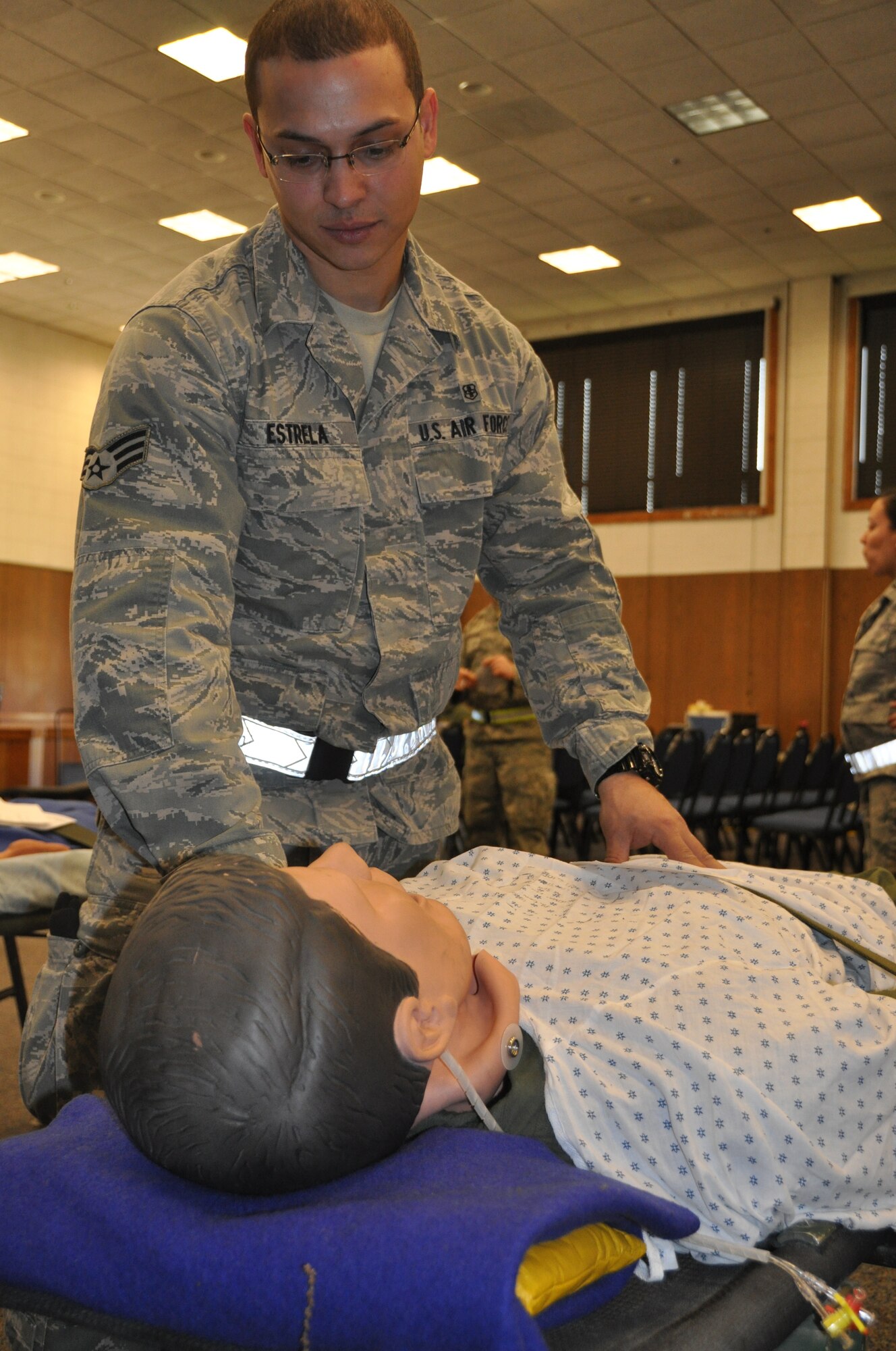 Senior Airman Jason Estrela, a medical technician, checks over a patient in the staging area to unsure that the patient’s condition is not deteriorating. The exercise mimicked emergency medical situation in the event of a disaster at Joint Base Andrews on Monday, May 4, 2015 (Air Force Photo / Senior Airman Kristin Kurtz)