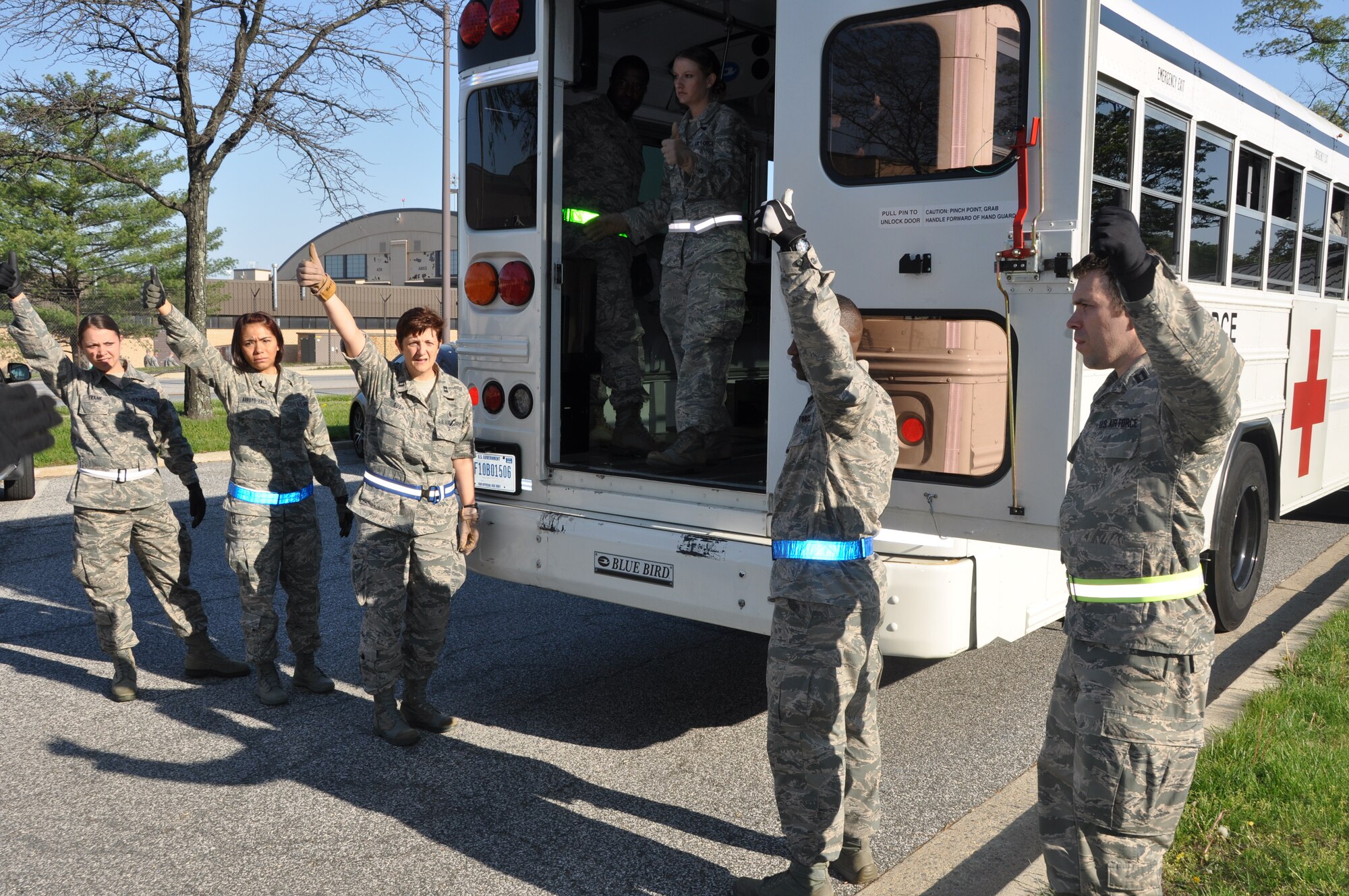 Members of the 459th Aeromedical Staging Squadron signal that they are ready to receive patients from the incoming bus. The exercise mimicked emergency medical situation in the event of a disaster at Joint Base Andrews on Monday, May 4, 2015 (Air Force Photo / Senior Airman Kristin Kurtz)
