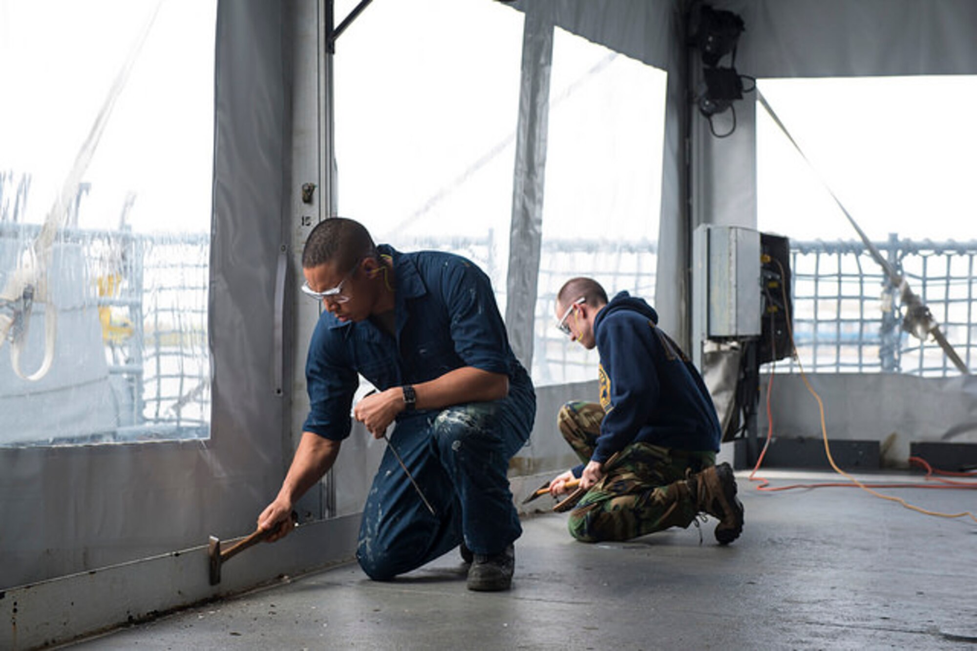 Sailors from Joint Base McGuire-Dix-Lakehurst remove paint and rust from the Battleship New Jersey, May 1, 2015. Service members volunteered to help restore the historic battleship, removing rust from the helicopter deck and hanging awnings throughout the ship. (U.S. Air Force photo by Airman 1st Class Joshua King)