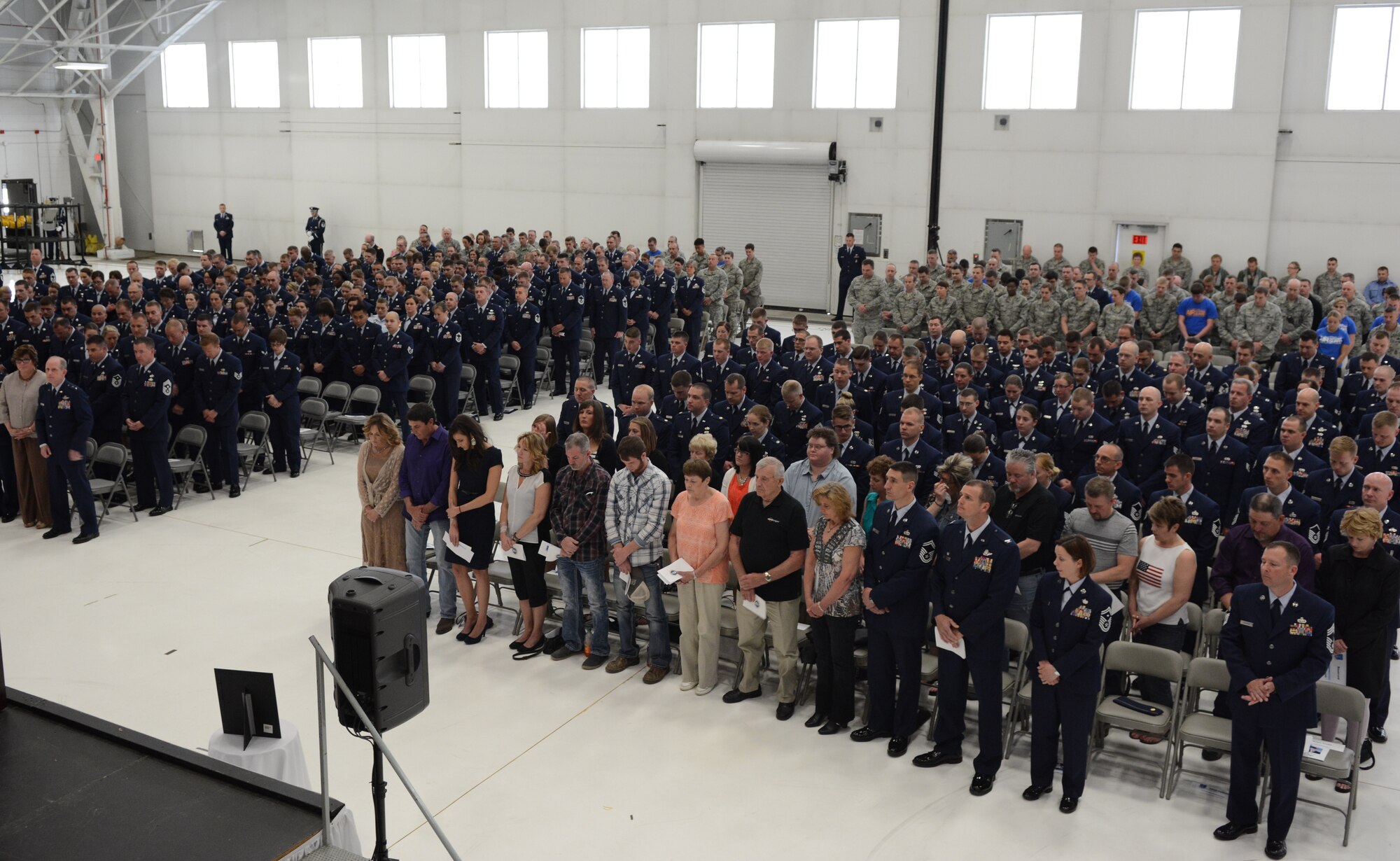 Attendees bow their heads for an opening prayer during Airman 1st Class Kelly C. Tomfohrde's memorial service, May 3. Airmen of the 115 FW, family members and friends gathered to honor Tomfohrde's service, sacrifices and to recognize her achievements and dedication during the memorial service on base. (U.S. Air National Guard photo by Tech. Sgt. Tiffany Black)