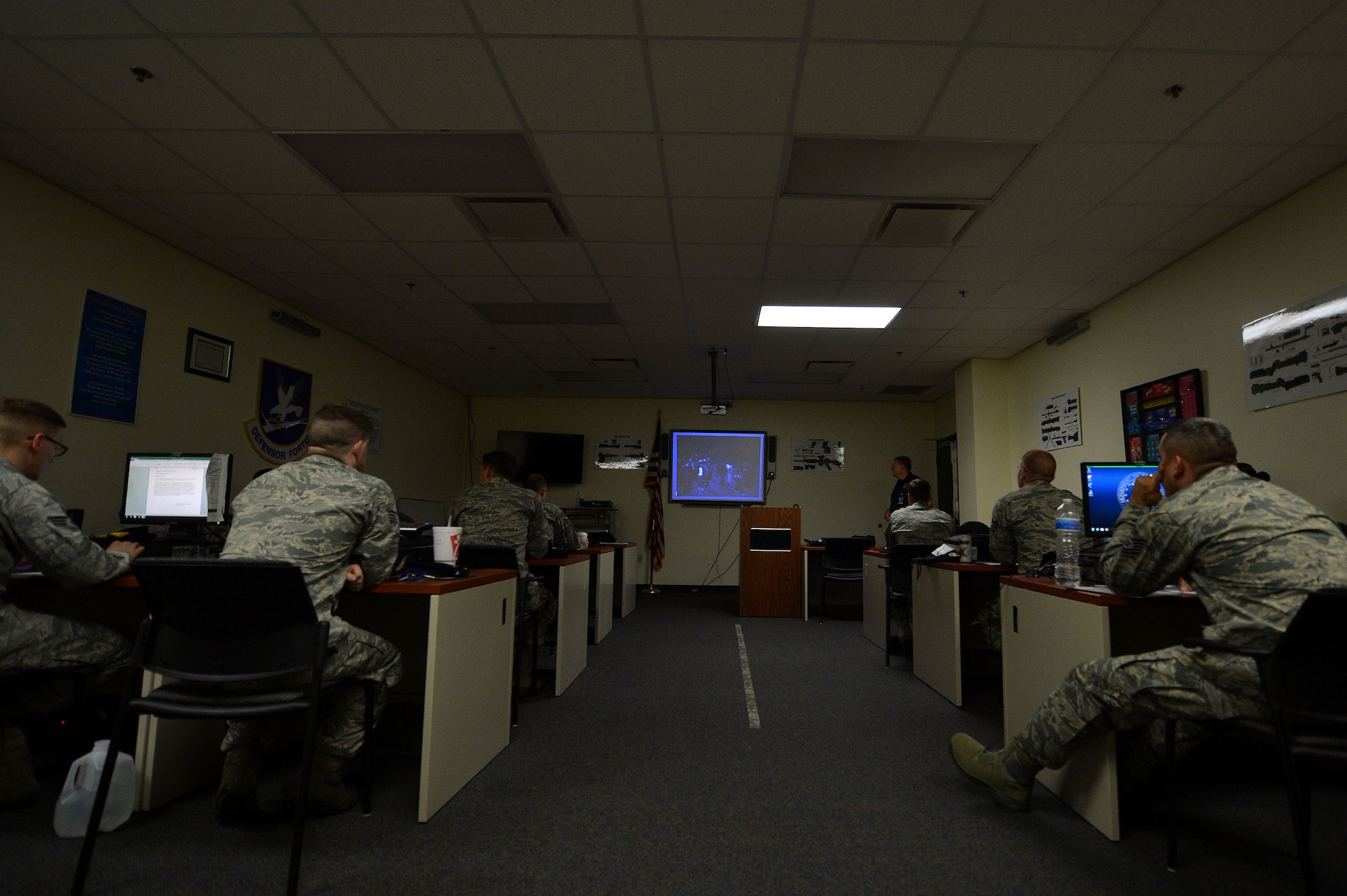 U.S. Air Force Airmen assigned to the 20th Security Forces Squadron watch an introduction video to the military customs inspector class at Shaw Air Force Base, S.C., April 28, 2015. During the class Airmen learned how to perform customs inspections on military aircraft, vehicles, and personnel. (U.S. Air Force photo by Airman 1st Class Michael Cossaboom/Released)