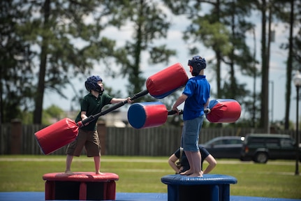 Two children battle with pugil sticks during the annual base picnic May 1, 2015 at Joint Base Charleston, S.C. The two-day event, included free food, live music, an inflatable obstacle course, a rock-climbing wall, a military working dog demo, prizes and demonstrations from local organizations . These organizations provide support to service members throughout the year. (U.S. Air Force photo/Senior Airman Jared Trimarchi) 