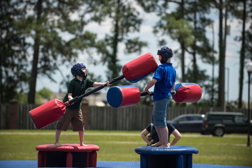 Two children battle with pugil sticks during the annual base picnic May 1, 2015 at Joint Base Charleston, S.C. The two-day event, included free food, live music, an inflatable obstacle course, a rock-climbing wall, a military working dog demo, prizes and demonstrations from local organizations . These organizations provide support to service members throughout the year. (U.S. Air Force photo/Senior Airman Jared Trimarchi) 