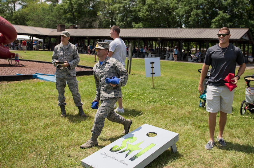 Maj. Samual Shimp, 628th Comptroller Squadron commander tosses a bean bag May 1, 2015 at Joint Base Charleston, S.C., during the annual base picnic. The two-day event included free food, live music, an inflatable obstacle course, a rock-climbing wall, a military working dog demo, prizes and demonstrations from local organizations. These organizations provide support to service members throughout the year. (U.S. Air Force photo/Senior Airman Jared Trimarchi) 