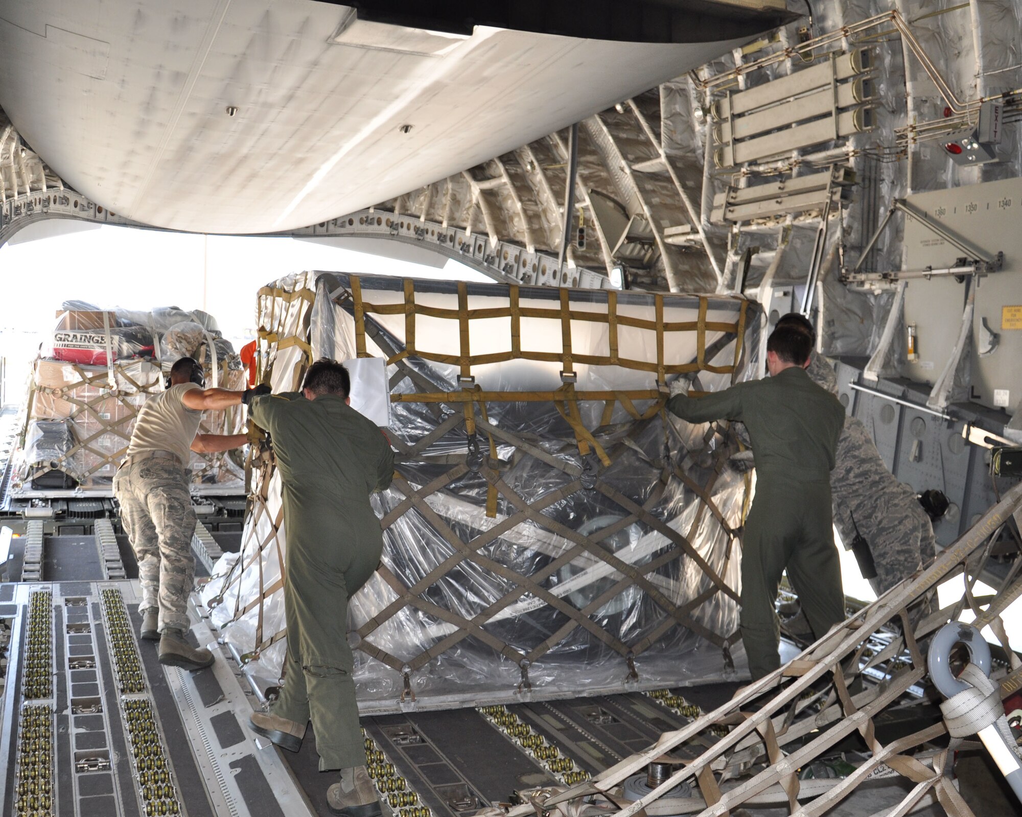 U.S. Air Force loadmasters and aerial porters load a pallet onto a C-17 Globemaster III as part of preparations to deploy to Uda Pao, Thailand, Joint Base Pearl Harbor-Hickam, Hawaii, May 1, 2015. The aircraft carried supplies and a joint team of U.S. service members from U.S. Pacific Command in support of the U.S. Agency for International Development's operations in Nepal. (U.S. Air Force photo by Maj. Ashley Conner/Released)