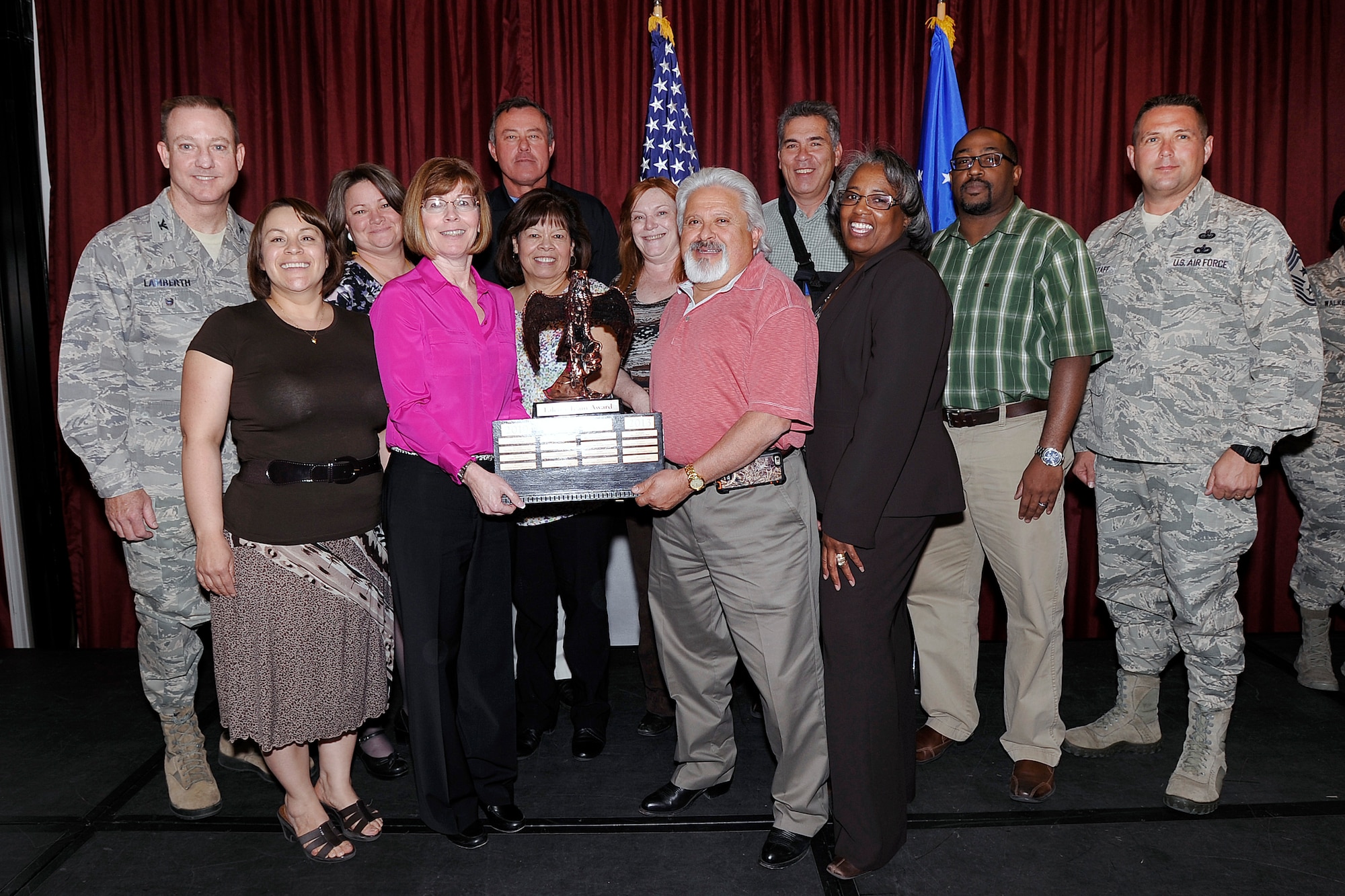Col. Kevin Lamberth (left), the U.S. Air Force Academy's vice superintendent, and Chief Master Sgt. Max Grindstaff, the Academy's command chief, stand on stage with a group of 1st Quarter quarterly awards winners April 30, 2015 at the Falcon Club. These civilians were recognized for their outstanding efforts at the 1st Quarter Awards Luncheon here. (U.S. Air Force photo/Mike Kaplan)