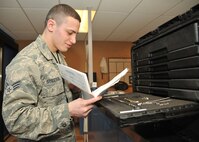 Senior Airman Kyle Struecker, 69th Maintenance Squadron crew chief, looks over an instruction guide of each tool at the 69th Maintenance support shop on Grand Forks Air Force Base, N.D., March 31, 2015. The support shop provides tools, safety equipment and machinery to be used to repair and maintain parts on an aircraft. (U.S. Air Force photo by Senior Airman Xavier Navarro/released)