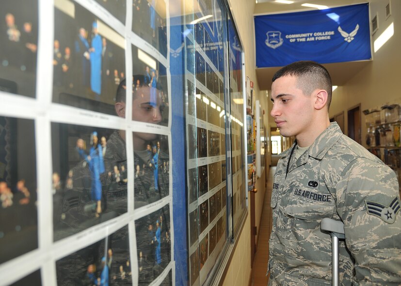 Senior Airman Kyle Struecker, 69th Maintenance Squadron crew chief, looks at Airmen from Grand Forks Air Force Base who earned their Community College of the Air Force degree at the Education Center on March 31, 2015, on Grand Forks Air Force Base, N.D.  The CCAF is a federally-chartered degree-granting institution that serves the United States Air Force’s enlisted total force. The college annually awards more than 22,000 associates in applied science degree from 69 degree programs. (U.S. Air Force photo by Senior Airman Xavier Navarro/released)