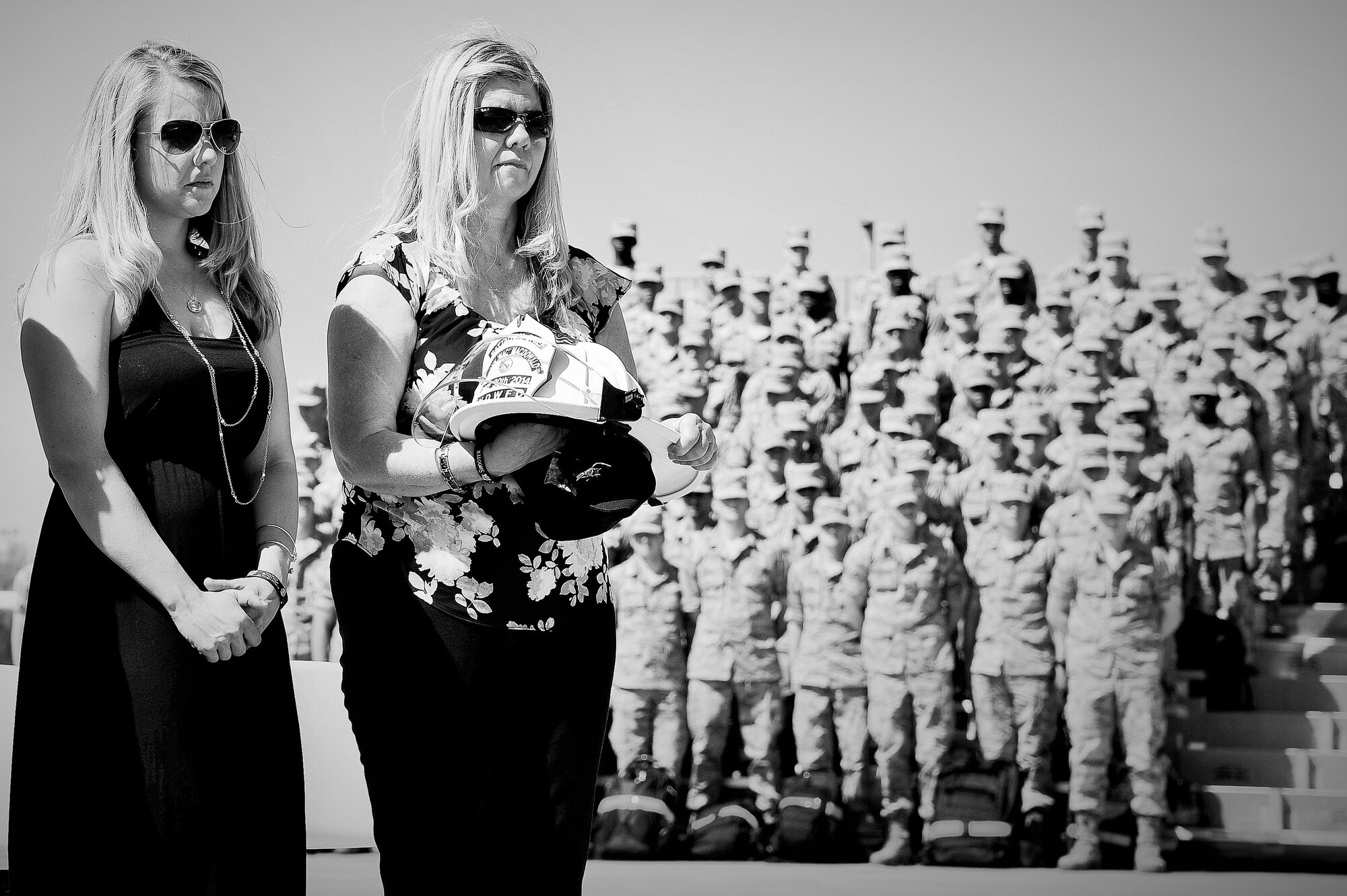 The family of Battalion Chief John McDonald, daughter Ashley McDonald and wife Teresa McDonald, stand in a moment of silence after being presented with a helmet to honor Battalion Chief McDonald during the Fallen Firefighter Ceremony at the Department of Defense Fallen Firefighters’ Memorial on Goodfellow Air Force Base, Texas, May 1, 2015. Battalion Chief McDonald is the latest fallen firefighter to be added to the DOD Fallen Firefighters’ Memorial. (U.S. Air Force photo by Tech. Sgt. Austin Knox/Released)
