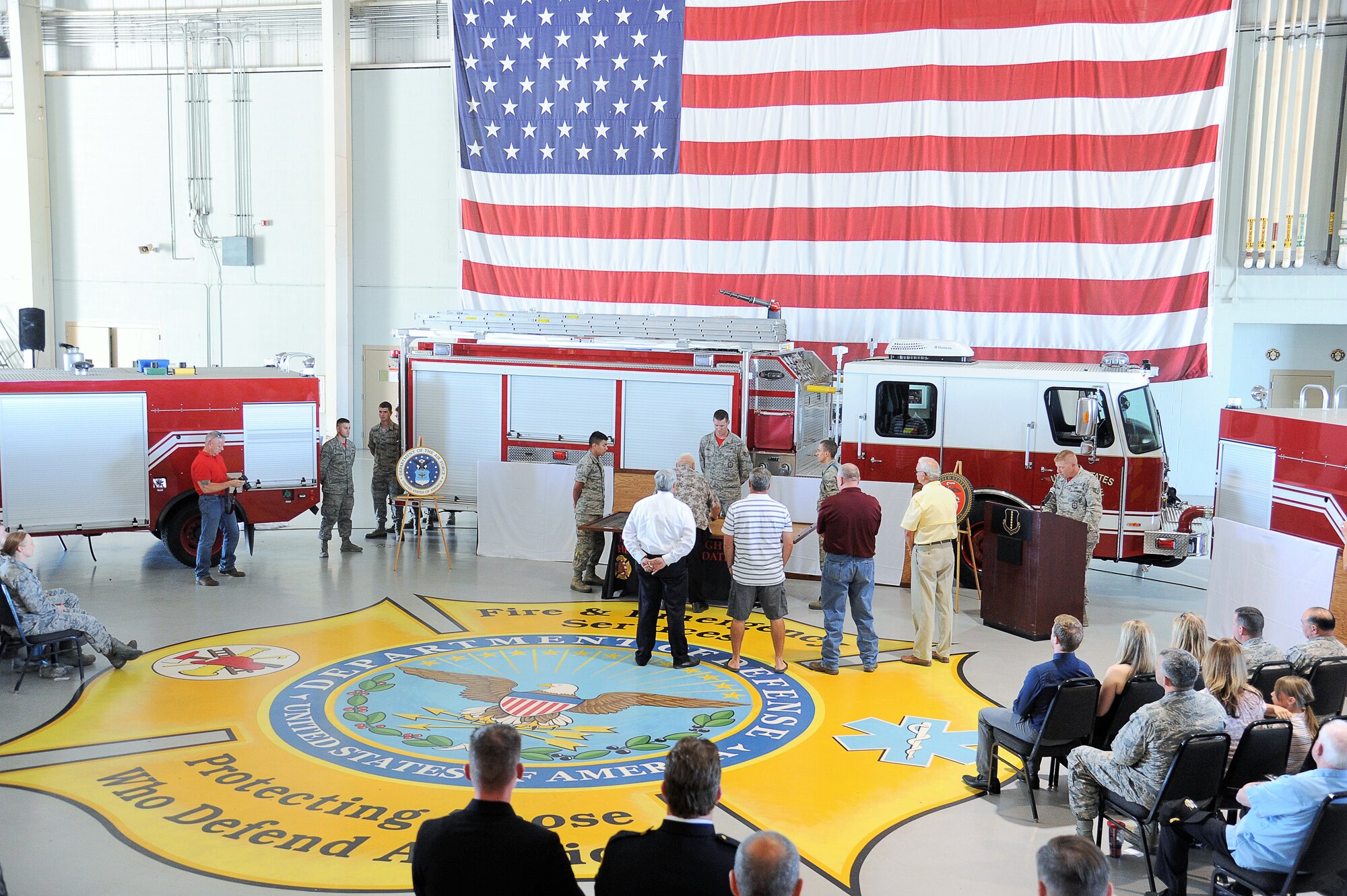 Former firefighting instructors stand-by to hammer their name tapes onto a display board at the Louis F. Garland Department of Defense Fire Academy high bay on Goodfellow Air Force Base, Texas, May 1, 2015. The academy hosted its 20th anniversary celebration honoring past and present instructors and the academy’s heritage. (U.S. Air Force photo by Tech. Sgt. Austin Knox/Released)