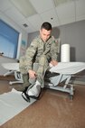 Senior Airman Kyle Struecker, 69th Maintenance Squadron crew chief, puts his camboot on in order to stablize his healing foot at the Medical Facility on March 31, 2015, on Grand Forks Air Force Base, N.D. Struecker utilizes many medical facilities such as physical therapy to help him recover to get his mission done. (U.S. Air Force photo by Senior Airman Xavier Navarro/released)