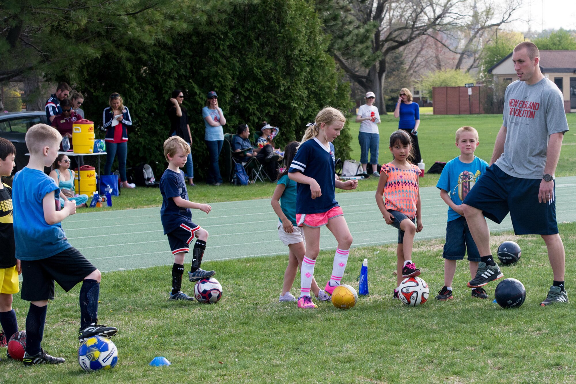 Brad Knighton, a professional soccer player for the New England Revolution, leads base children through drills during a Revolution Academy session at the base running track May 4. The Revolution Academy is a fully-integrated training and development program for youth soccer players, ages 7 and up, in the New England and Western New York areas. (U.S. Air Force photo by Mark Herlihy)