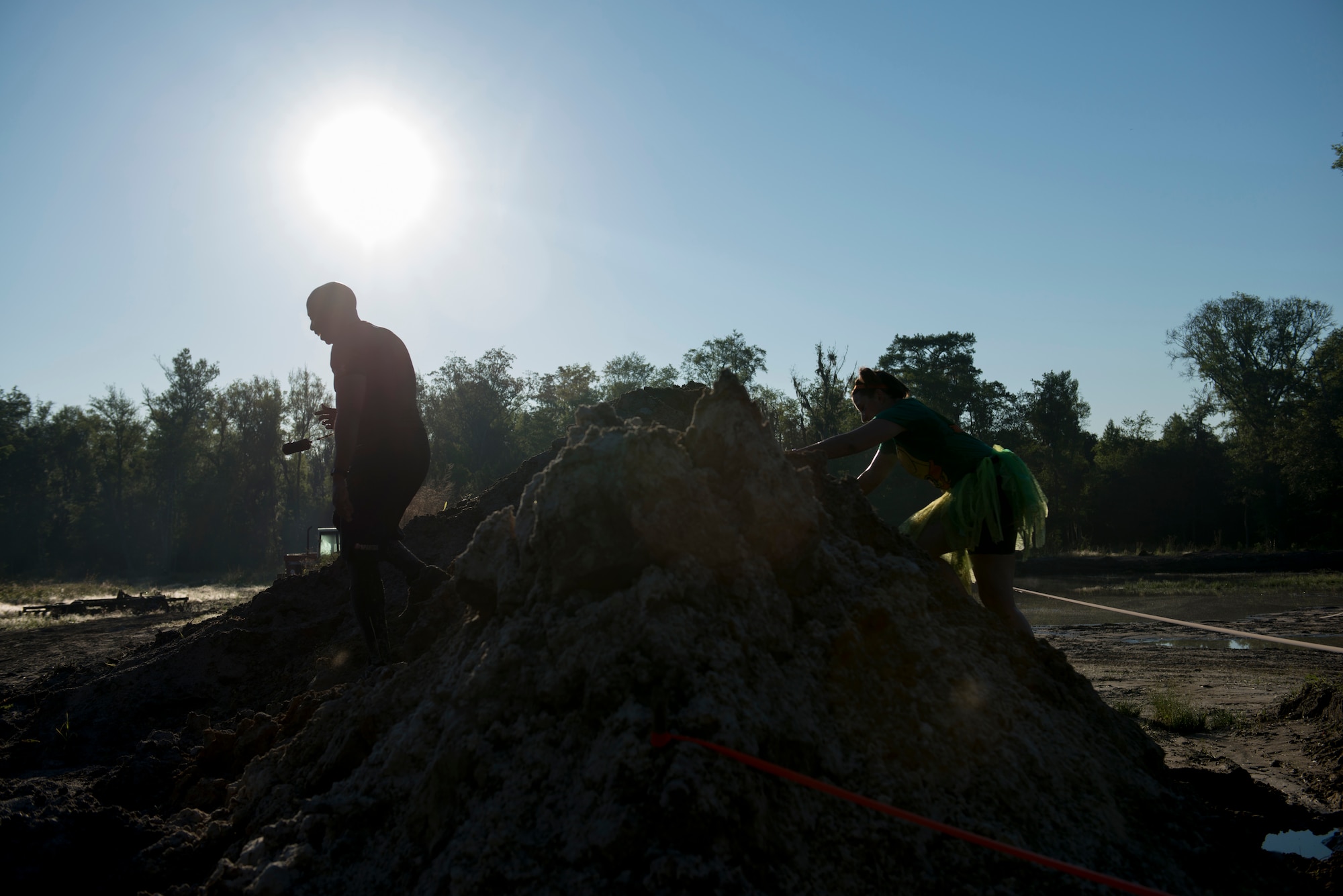 Runners climb over a rock wall during the 2015 Moody Mudder May 2, 2015, in Ray City, Ga.  Runners participated in many obstacles throughout the run such as a climbing wall, fire pit, low crawls, monkey bars and rock hills. (U.S. Air Force photo by Airman 1st Class Dillian Bamman/Released)