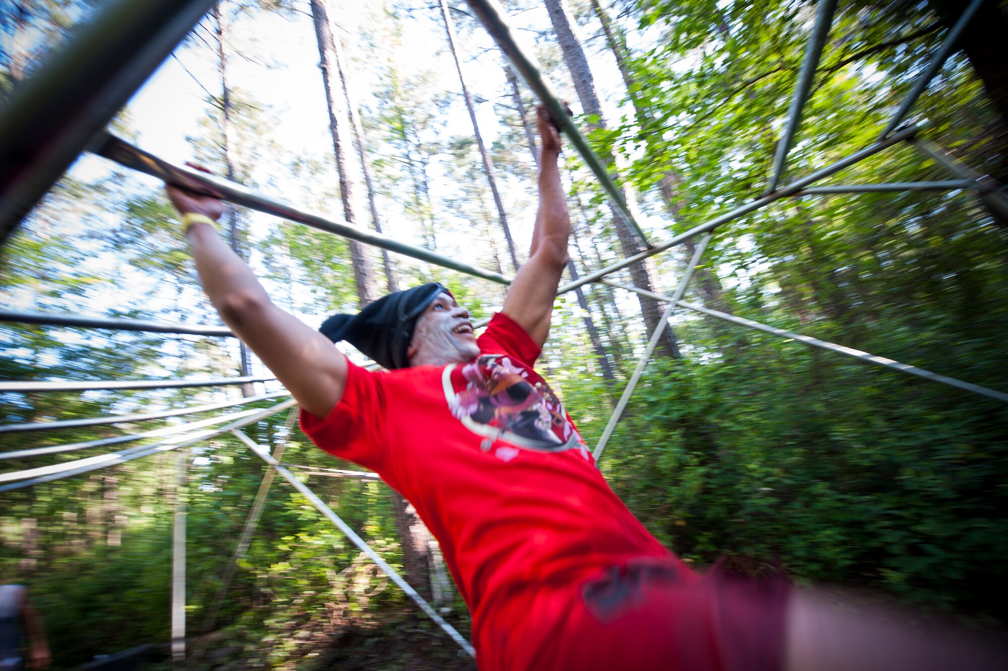A runner swings through a set of monkey bars during the 2015 Moody Mudder May 2, 2015, in Ray City, Ga. Runners participated in many obstacles throughout the run such as a climbing wall, fire pit, low crawls, monkey bars and rock hills. (U.S. Air Force photo by Airman 1st Class Dillian Bamman/Released)