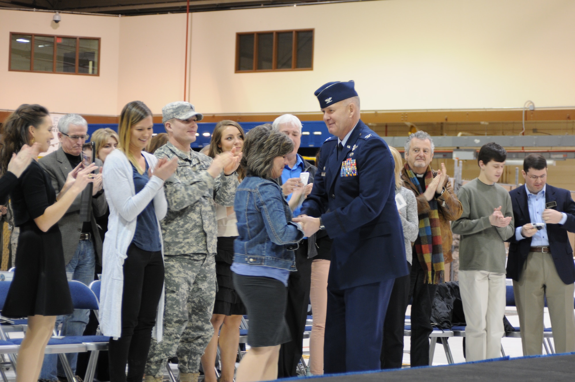 Col. Pete Hronek presents his first commander’s coin to his wife, Tracy, for her years of support of the 120th Airlift Wing’s Airmen during the unit’s change of command ceremony March 7, 2015 in Great Falls. (Montana Air National Guard photo/Tech. Sgt. Michael Touchette) 