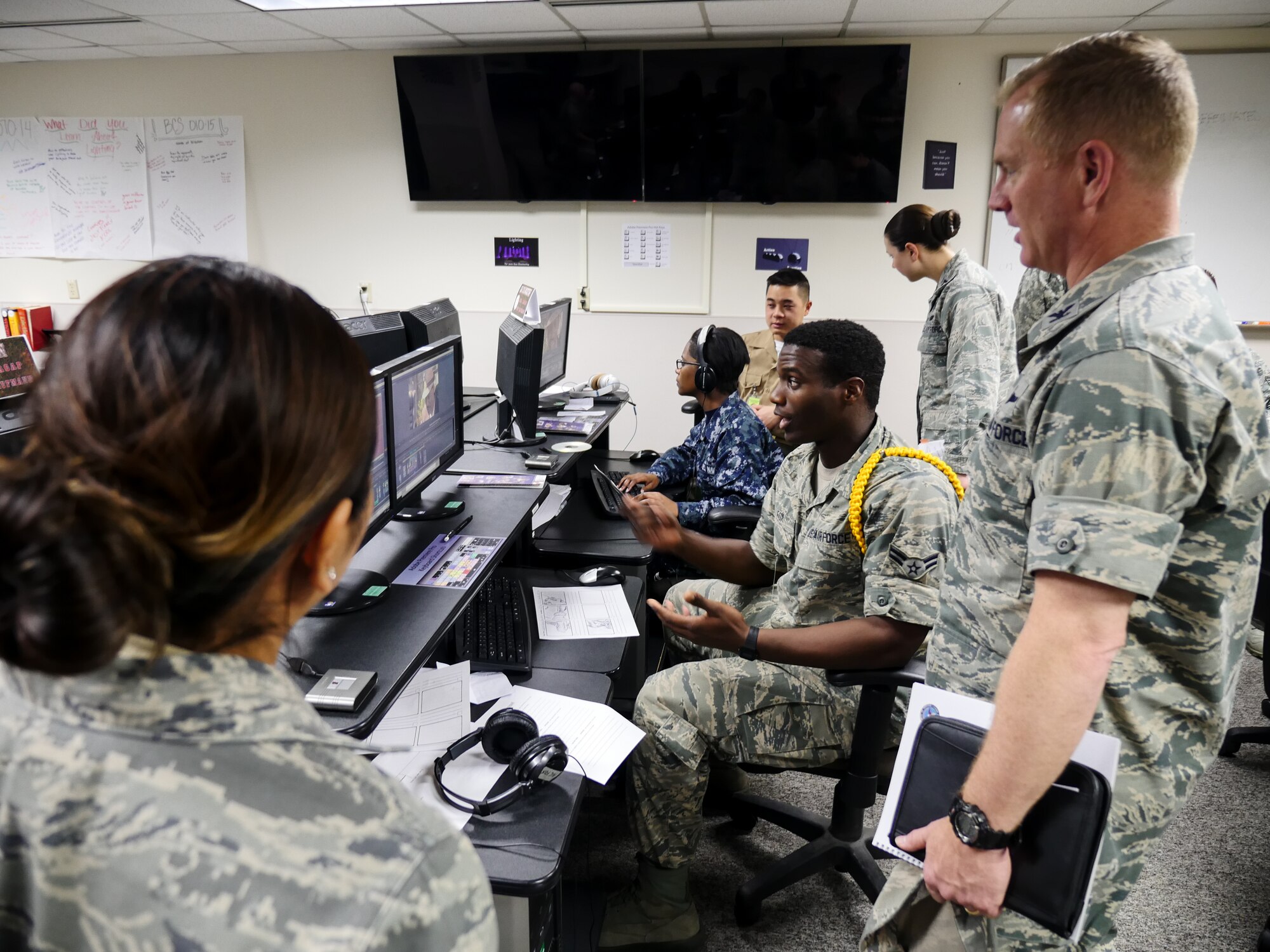 Airman 1st Class Mychal C. Fox, Broadcast Communication Specialist Class 040-15 student, shows Col. Dennis Scarborough, 81st Training Wing vice commander, his latest project at the Defense Information School, May 1, 2015, Fort Meade, Md. Scarborough visited DINFOS to learn about the different classes offered to Air Force students, interact with Detachment 2, 336th Training Squadron members and DINFOS students. (DoD photo by Joseph Coslett)