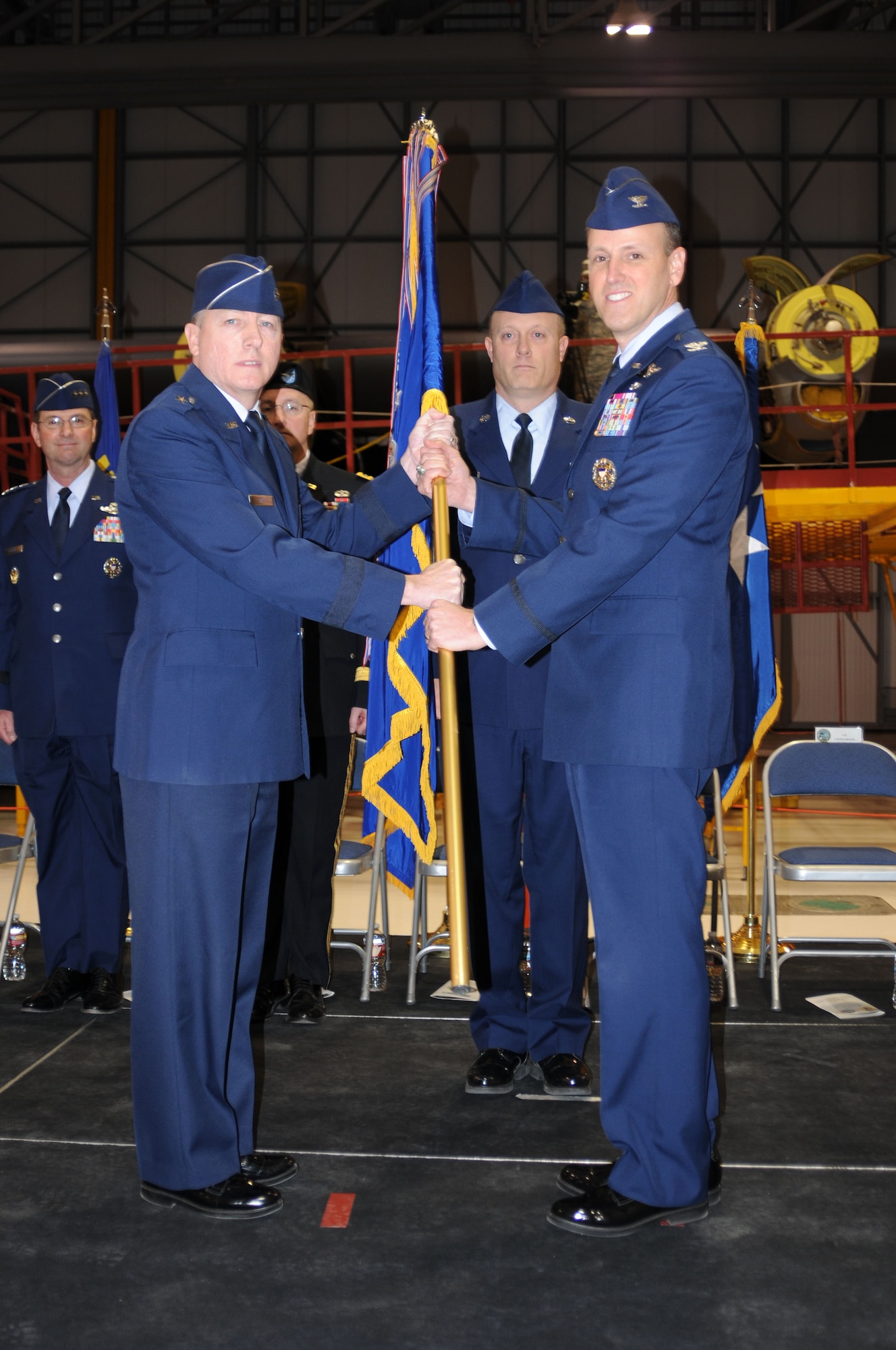Brigadier General Bryan P. Fox, the Assistant Adjutant General – Air, presents the unit flag of the 120th Airlift Wing to Col. Lee Smith during the change of command ceremony March 7, 2015 in Great Falls. (Montana Air National Guard photo/Tech. Sgt. Michael Touchette)
