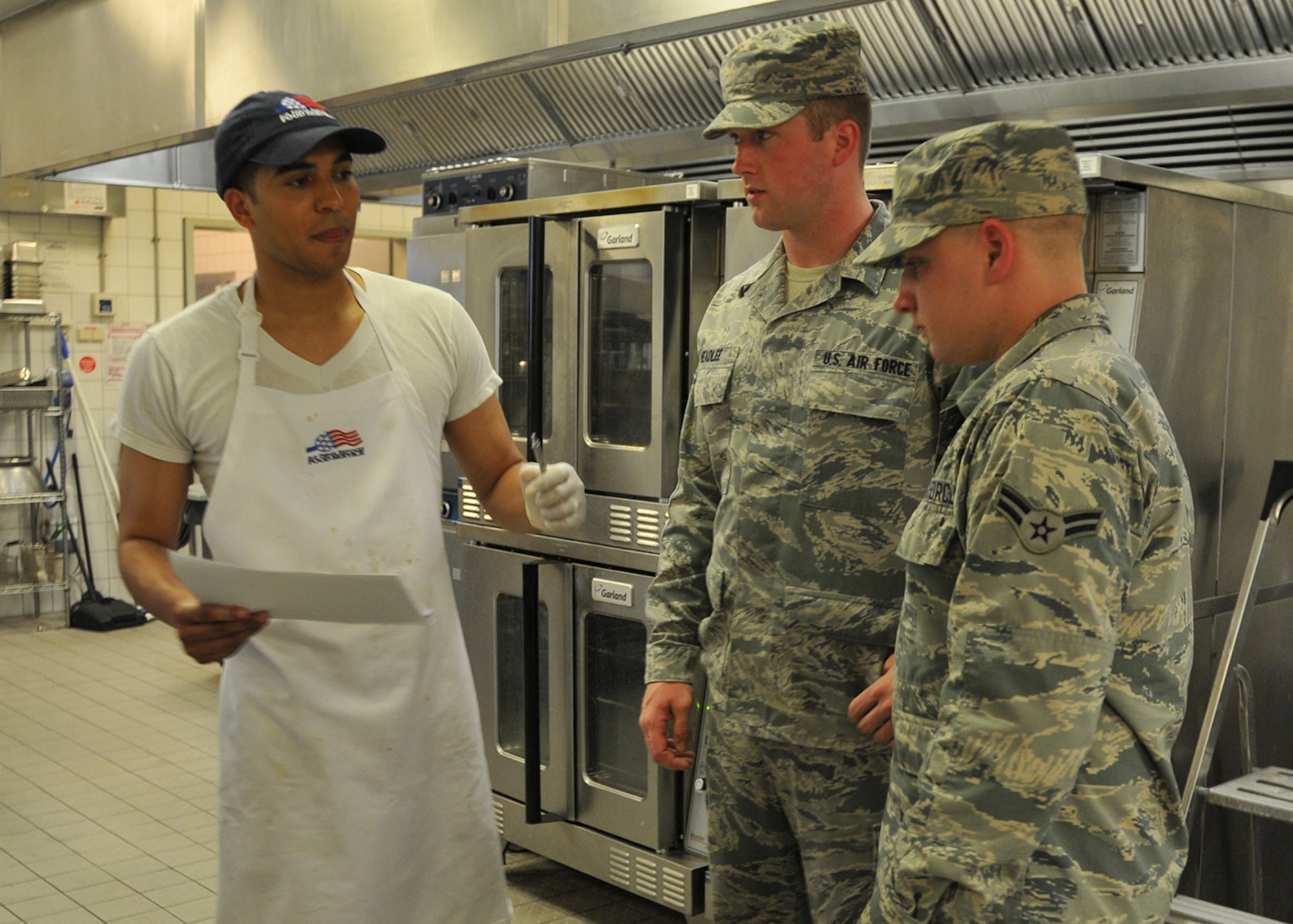 Senior Airman Barry Headlee and Airman 1st Class Brian Kulas, 104th Services Flight, Barnes Air National Guard Base, Westfield, Mass., train with Staff Sgt. Dennis Murphy, Rhineland dining facility shift supervisor May 5, 2015, Ramstein Air Base, Germany. The 104th Fighter Wing has deployed approximately 50 personnel to Ramstein Air Base, Germany, to integrate with active duty forces for deployed field training. (U.S. Air National Guard photo by Tech Sgt Melanie J. Casineau)