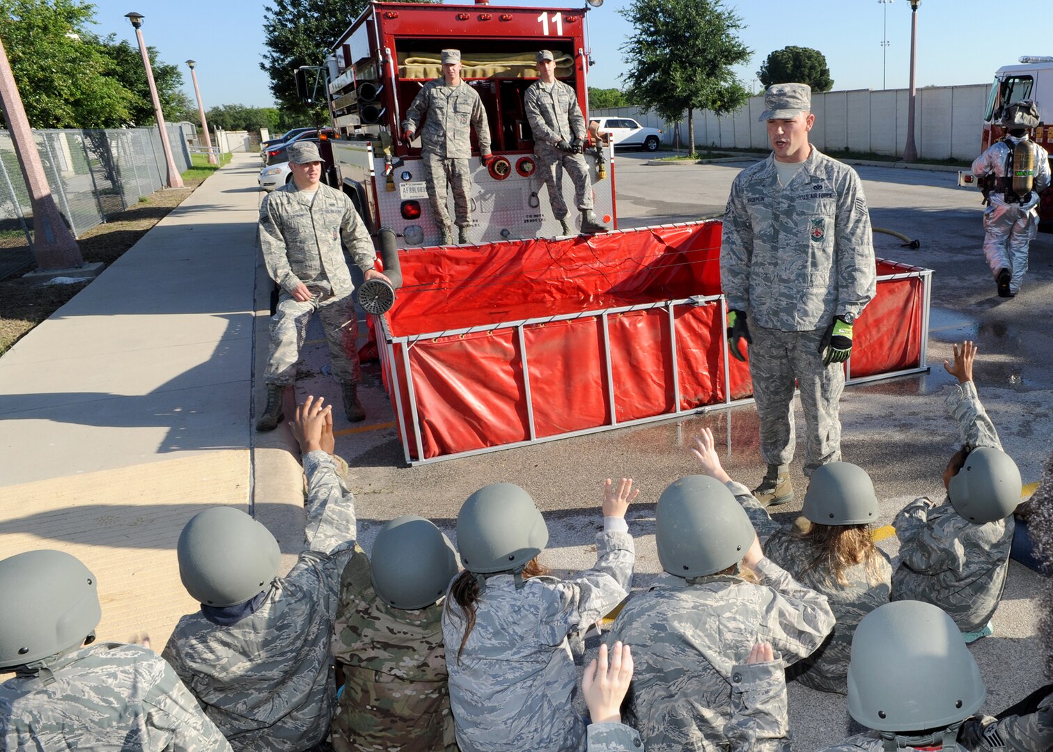 Staff Sgt. Luke Kroeplin (right), 502nd Civil Engineer Squadron firefighter at Joint Base San Antonio-Randolph, speaks to Randolph Elementary School fifth-graders about fire equipment and proper procedures during Operation Families Learning About Global Support May 1 at JBSA-Randolph. During the annual event, the children are given the opportunity to experience the pre-deployment, deployment and reintegration processes that parents face when deploying.  (U.S. Air Force photo by Melissa Peterson)