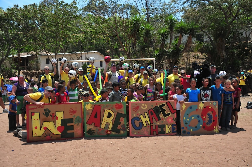 SOTO CANO AIR BASE, Honduras – Hikers from Joint Task Force-Bravo pose with children from the mountain village of El Misterio, Honduras, following a 3.2-mile hike to deliver 3,000 pounds of rice and other items, as well as to interact with the villagers there April 18, 2015. This was the 60th iteration of the Joint Task Force-Bravo chapel hike program, which has delivered more than 217,000 pounds of donated goods to people in need in remote areas, to show good will and build trust in Honduras. (U.S. Air Force photo by Staff Sgt. Jessica Condit)