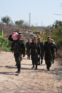 SOTO CANO AIR BASE, Honduras – A group of cadets from the Honduran Air Force Academy leads the way, as 222 hikers from the U.S. and Honduras begin a 3.2-mile climb to the mountain village of El Misterio, Honduras, April 18, 2015, to deliver a combined 3,000 pounds of rice and other goods to the villagers there. This was the 60th iteration of the Joint Task Force-Bravo chapel hike program, which has delivered more than 217,000 pounds of donated goods to people in need in remote areas, to show good will and build trust in Honduras. (U.S. Air Force photo by Capt. Christopher Love)