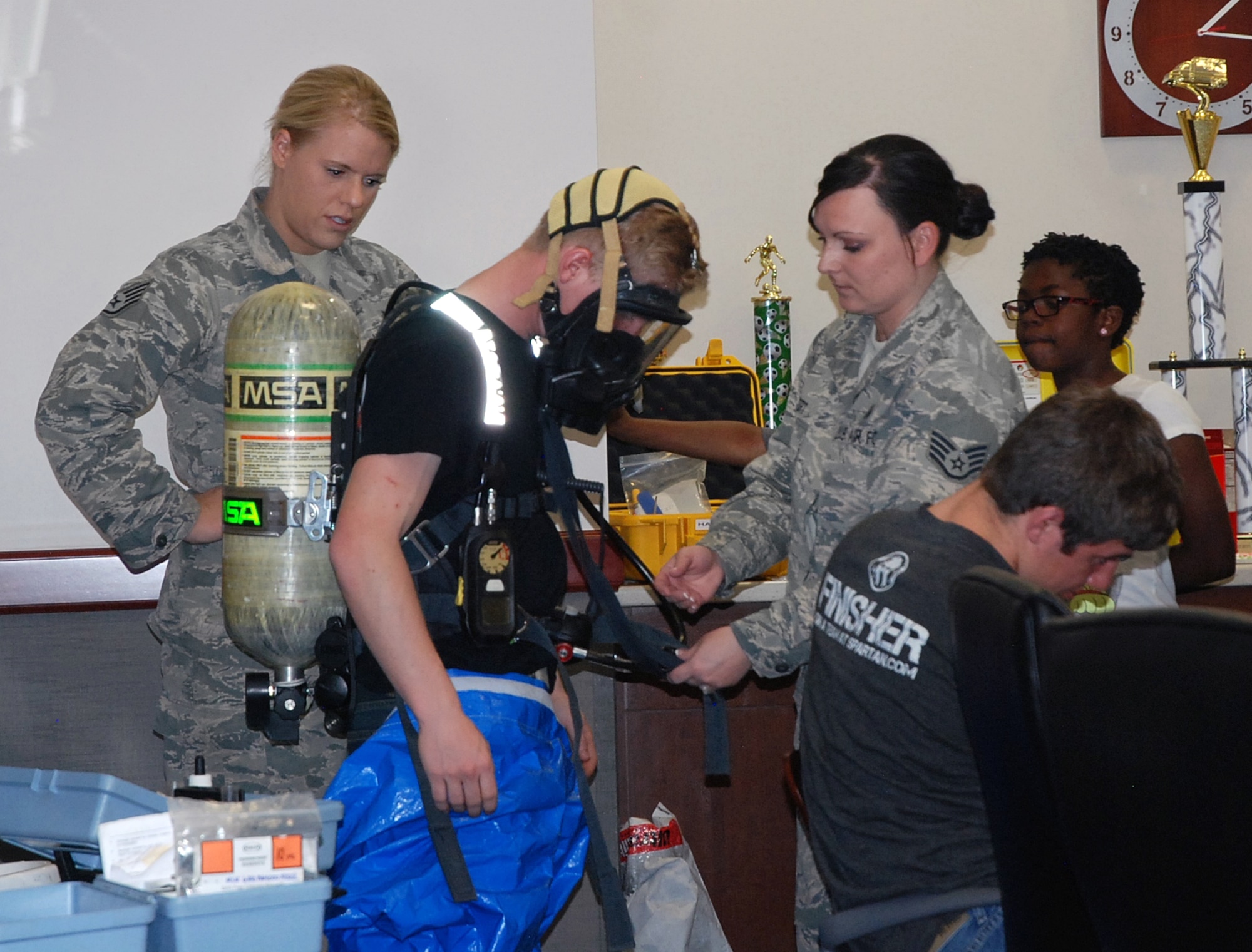 PETERSON AIR FORCE BASE, Colo. – Staff Sgts. Katherine Streepy (left), and Staci Eckert, 21st Medical Group Bioenvironmental Engineering Flight technicians, help Ryan Weatherbee suit up in a protective suit used in their line of work. The 21st MDG marked Bring Your Child to Work Day April 23 to showcase its mission capabilities. (U.S. Air Force photo by Dave Smith)