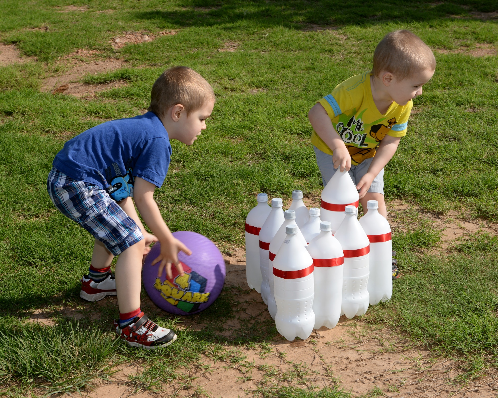 ALTUS AIR FORCE BASE, Okla. – Children play a game of soda bottle bowling at a deployed family event, May 2, 2015, near the mini-golf course. The event doubled as a grand opening to the base splash pad, with the deployed families being the first to get to use it. (U.S. Air Force photo by Airman 1st Class Megan E. Acs/Released)