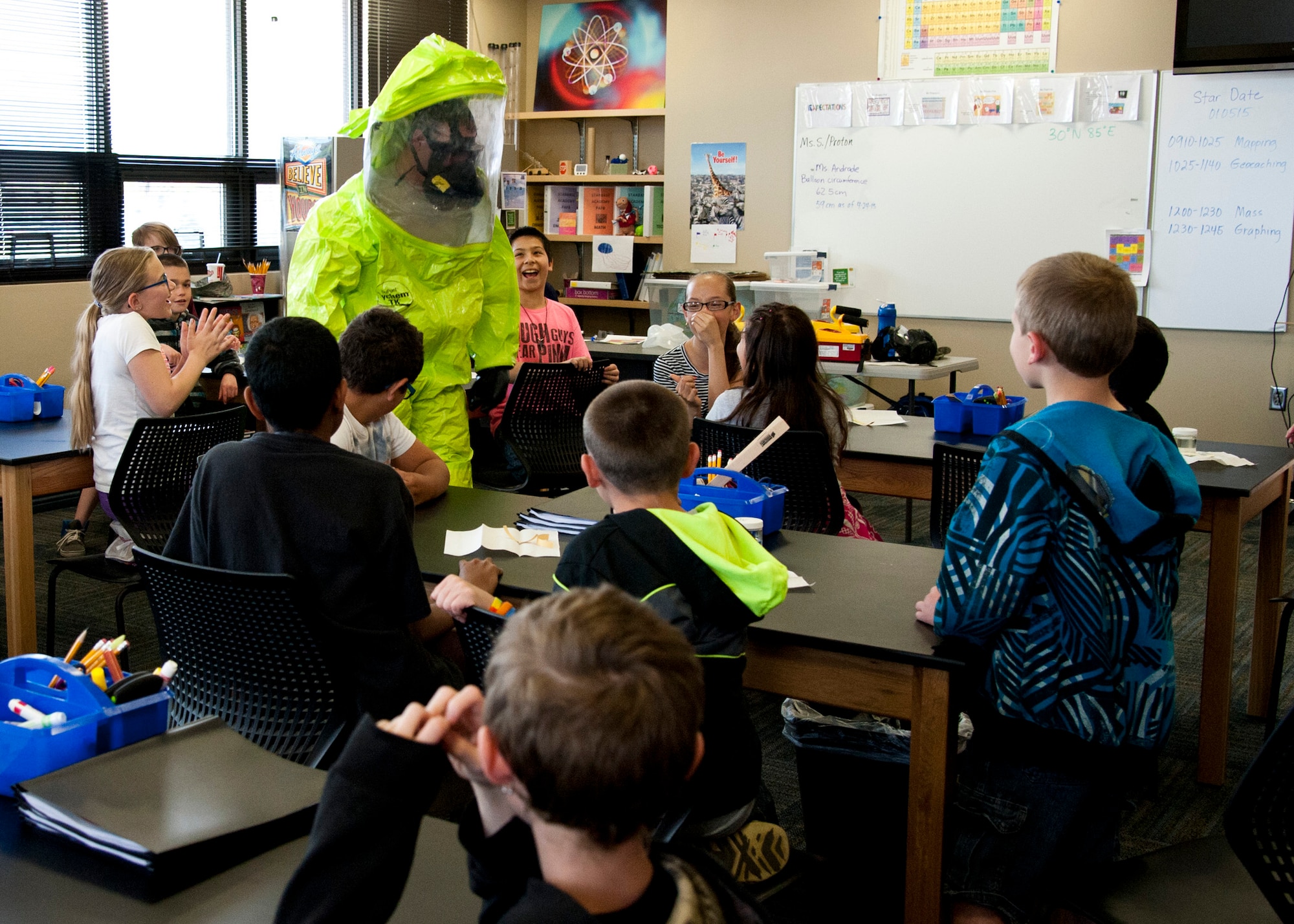 PETERSON AIR FORCE BASE, Colo. –Senior Airman James Boone, 21st Aerospace Medical Squadron bioenvironmental engineering technician, demonstrates the advantages and disadvantages of wearing the chemical suit to fifth grade students from Mark Twain Elementary at the STARBASE Academy, April 30, 2015. Staff Sgt. Jennifer Hobson and Boone described some of their daily duties and the science behind the chemical suits, and explained how they conduct water and chemical testing. STARBASE is a Department of Defense youth program where local students come to Peterson and learn about science, technology, engineering and math. (U.S. Air Force photo by Senior Airman Tiffany DeNault)