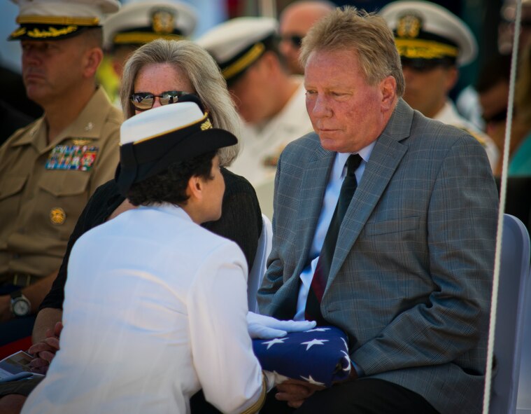 Vice Chief of Naval Operations Adm. Michelle Howard presents a flag to the family of a fallen explosive ordnance disposal technician at the EOD's 46th Annual Memorial Service at the Kauffman EOD Training Complex at Eglin Air Force Base, Fla., May 2. Eight names of Army, Marine and Navy service members were added to the EOD memorial wall. The all-service total now stands at 314. (U.S. Air Force photo/Tech. Sgt. Samuel King Jr.)