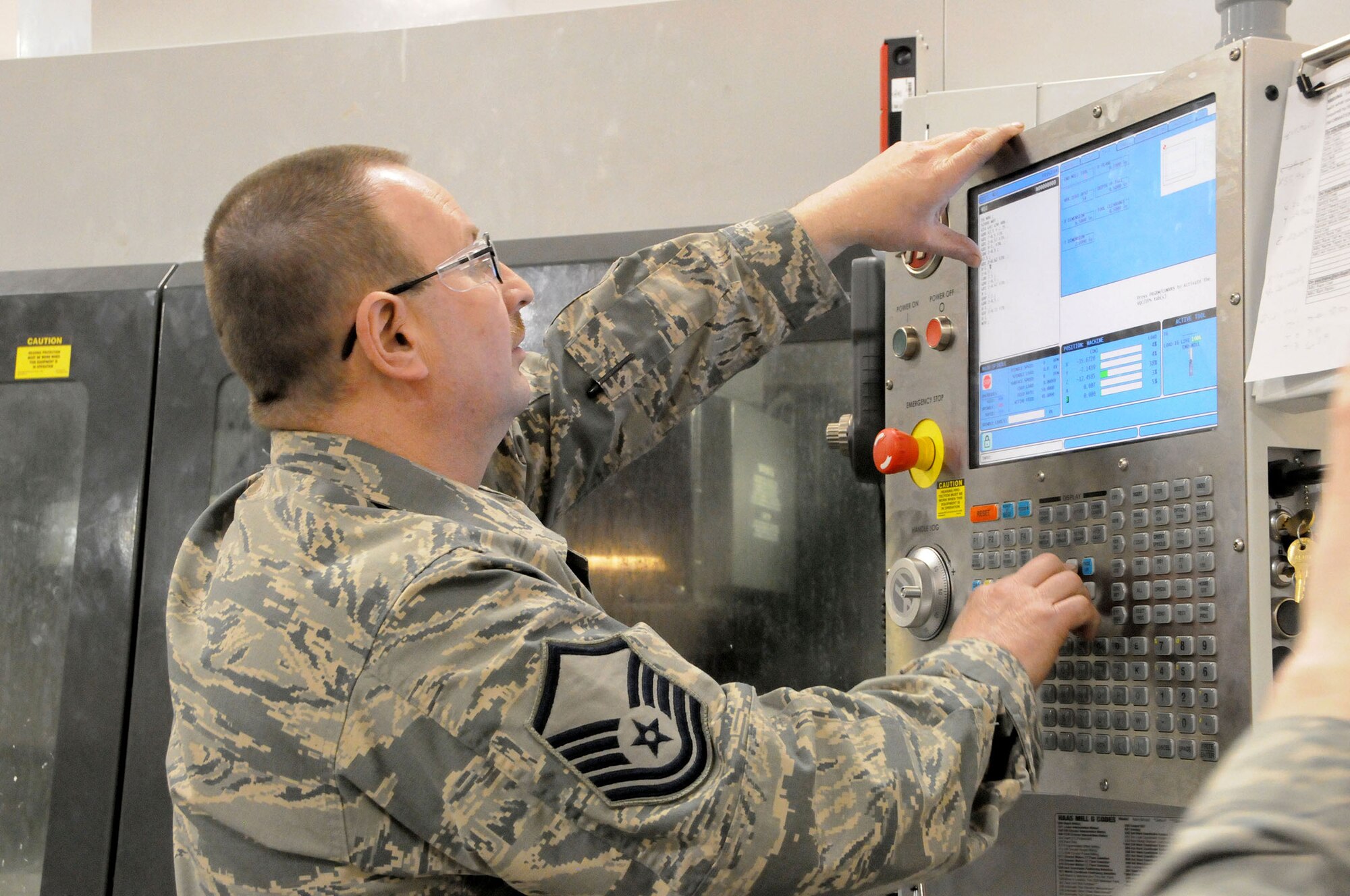WRIGHT-PATTERSON AIR FORCE BASE, Ohio – Master Sgt. Timothy Knight, 445th Maintenance Squadron metals technology technician, programs a 5-Axis Milling Machine for duplication of an aircraft part for a C-17 Globemaster III on April 11, 2015. The machine can be set up to duplicate any part that is not readily available. (U.S. Air Force photo/Tech. Sgt. Anthony Springer) 