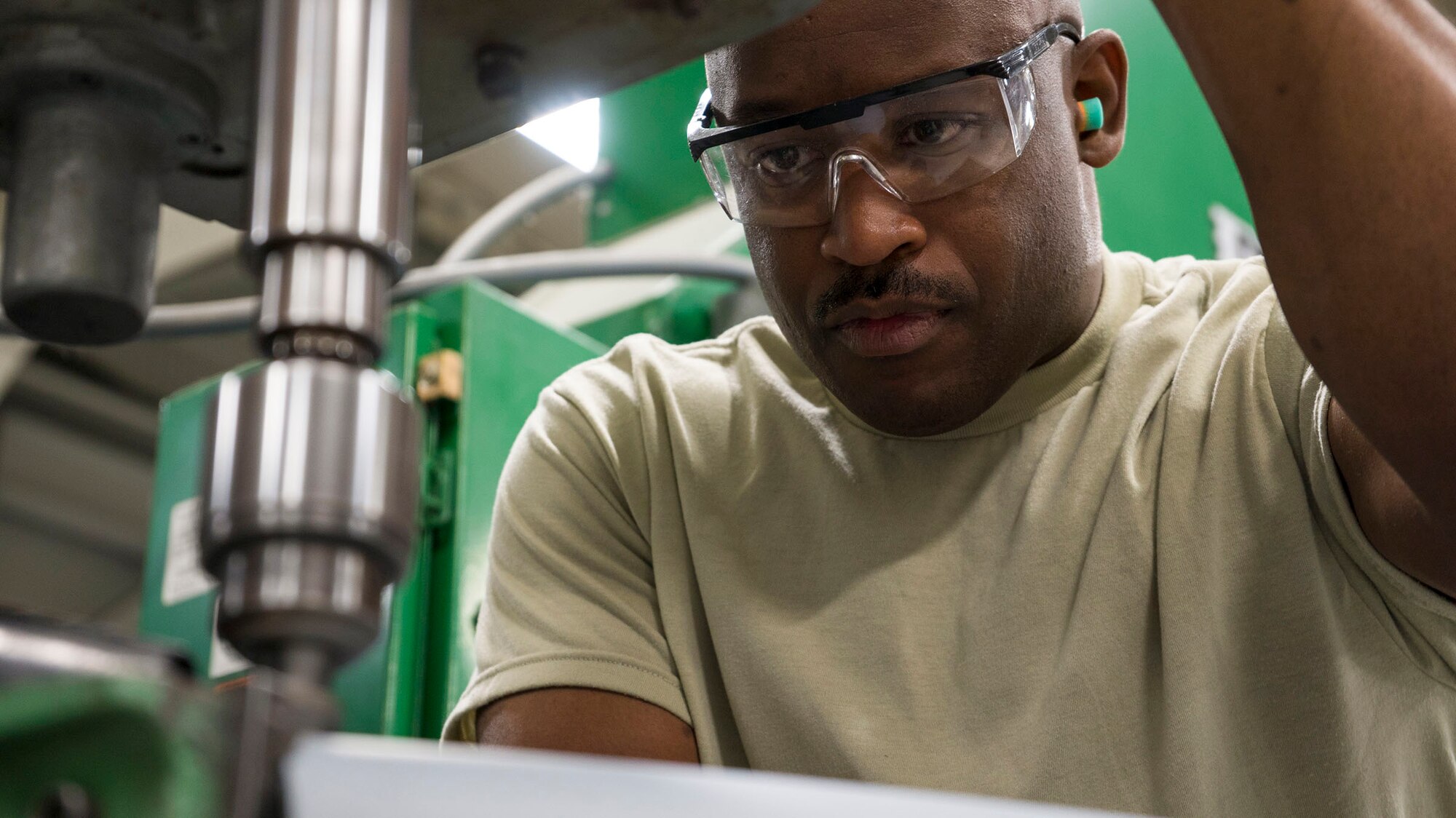 WRIGHT-PATTERSON AIR FORCE BASE, Ohio – Tech. Sgt. Aaron Bullucks, 445th Maintenance Squadron aircraft structural maintenance craftsman, operates a drill press preparing a jet engine pylon cowling for the replacement of mounting fasteners on April 11, 2015. The repair was essential for keeping a C-17 Globemaster III mission ready. (U.S. Air Force photo/Senior Airman Devin Long)  
