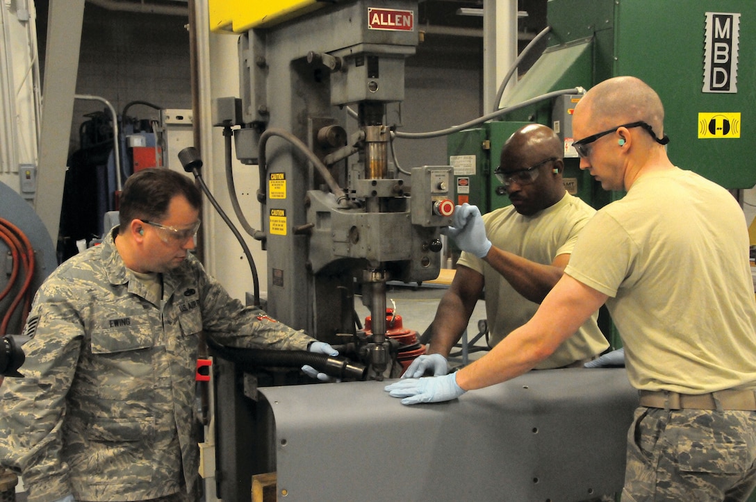 WRIGHT-PATTERSON AIR FORCE BASE, Ohio – (Left to right): Tech. Sgts. Gerald Ewing, Aaron Bullucks, and Brandon Sullivan, 445th Maintenance Squadron aircraft structural maintenance craftsmen, prepare a jet engine pylon cowling for the replacement of mounting fasteners on April 11, 2015. The repair was essential for keeping a C-17 Globemaster III mission ready. (U.S. Air Force Photo/Tech. Sgt. Anthony Springer) 