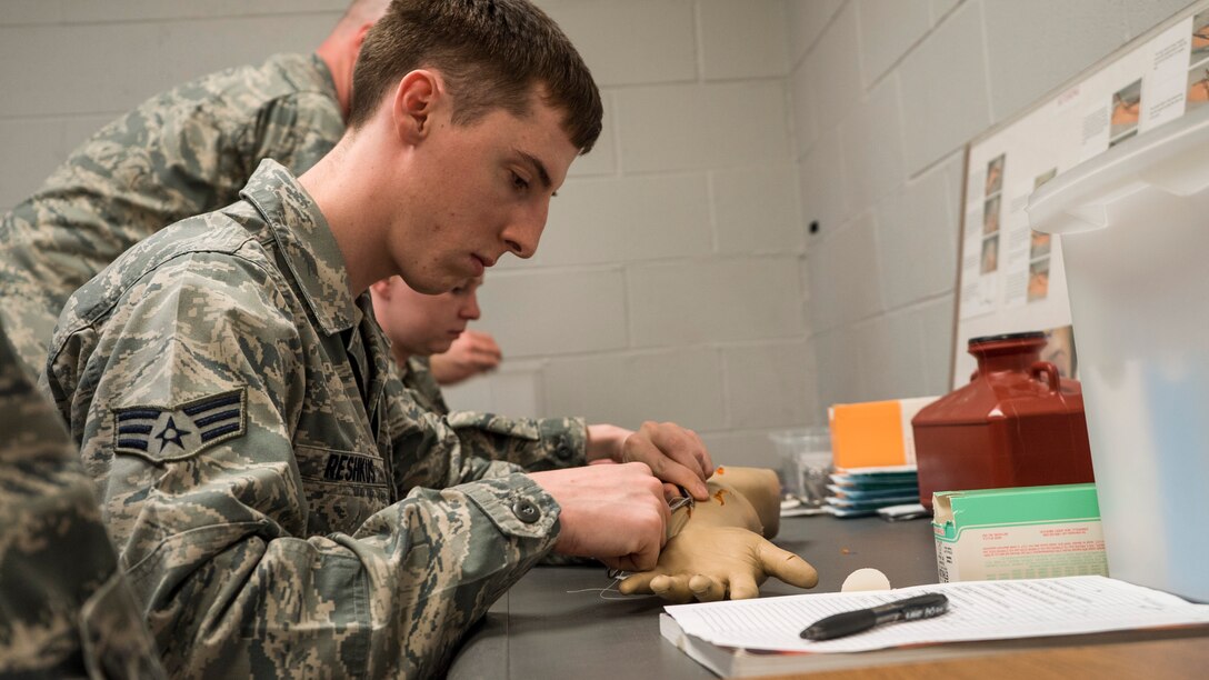 WRIGHT-PATTERSON AIR FORCE BASE, Ohio - Senior Airman Jonathan Reshkus, 445th Aeromedical Staging Squadron medical technician, practices suturing a fake arm during Readiness Skills Verification training April 11, 2015. Every year the Airmen of the 445th ASTS must update their competency by retraining in multiple tasks. RSV tasks include patient assessment, suturing minor lacerations and vital signs. (U.S. Air Force photo/Senior Airman Devin Long) 