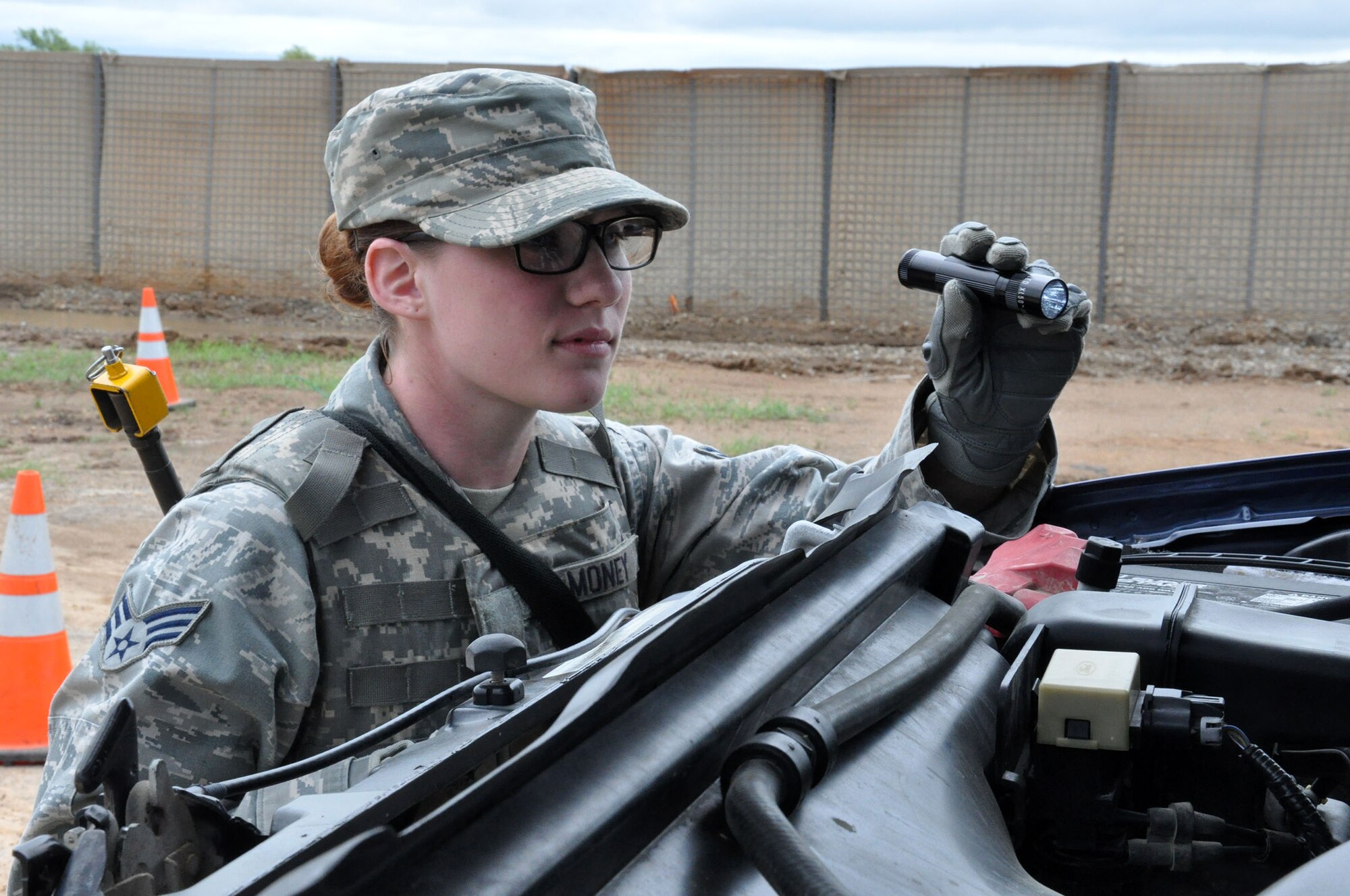 FORT WOLTERS TRAINING CENTER, Texas - Senior Airman Shelby Money, 445th Security Forces Squadron fire team member, inspects under a vehicle hood during an entry control point search pit operations. Money was one of 37 445th SFS Airmen who attended Patriot Defender training at Fort Wolters Training Center, Texas, April 6-17, 2015. Patriot Defender sustainment training takes SFS troops through the paces of core security forces tasks. (U.S. Air Force photo/Capt. Elizabeth Caraway)