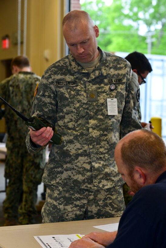 U.S. Army Maj. Jason Engelbrecht, Joint Task Force-Civil Support future operations planner, receives his assigned radio frequency during exercise Vibrant Response 15 at Fort Eustis, Va., April 30, 2015. The exercise promotes the realistic integration of chemical, biological, radiological and nuclear response units in response to CBRN events. (U.S. Air Force photo by Senior Airman Kimberly Nagle/Released)  