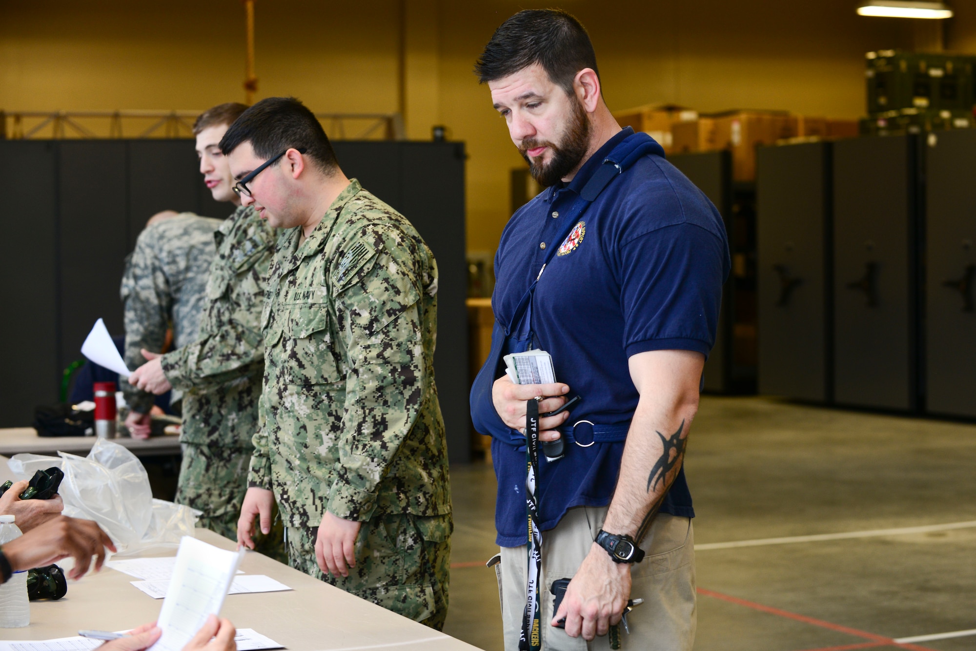 Karl Ludwig, Joint Task Force-Civil Support communications engineer, processes through a line, collecting the items he needs during exercise Vibrant Response 15 at Fort Eustis, Va., April 30, 2015. Items issued in the line prepared exercise participants for nuclear disaster response scenarios. (U.S. Air Force photo by Senior Airman Kimberly Nagle/Released)  