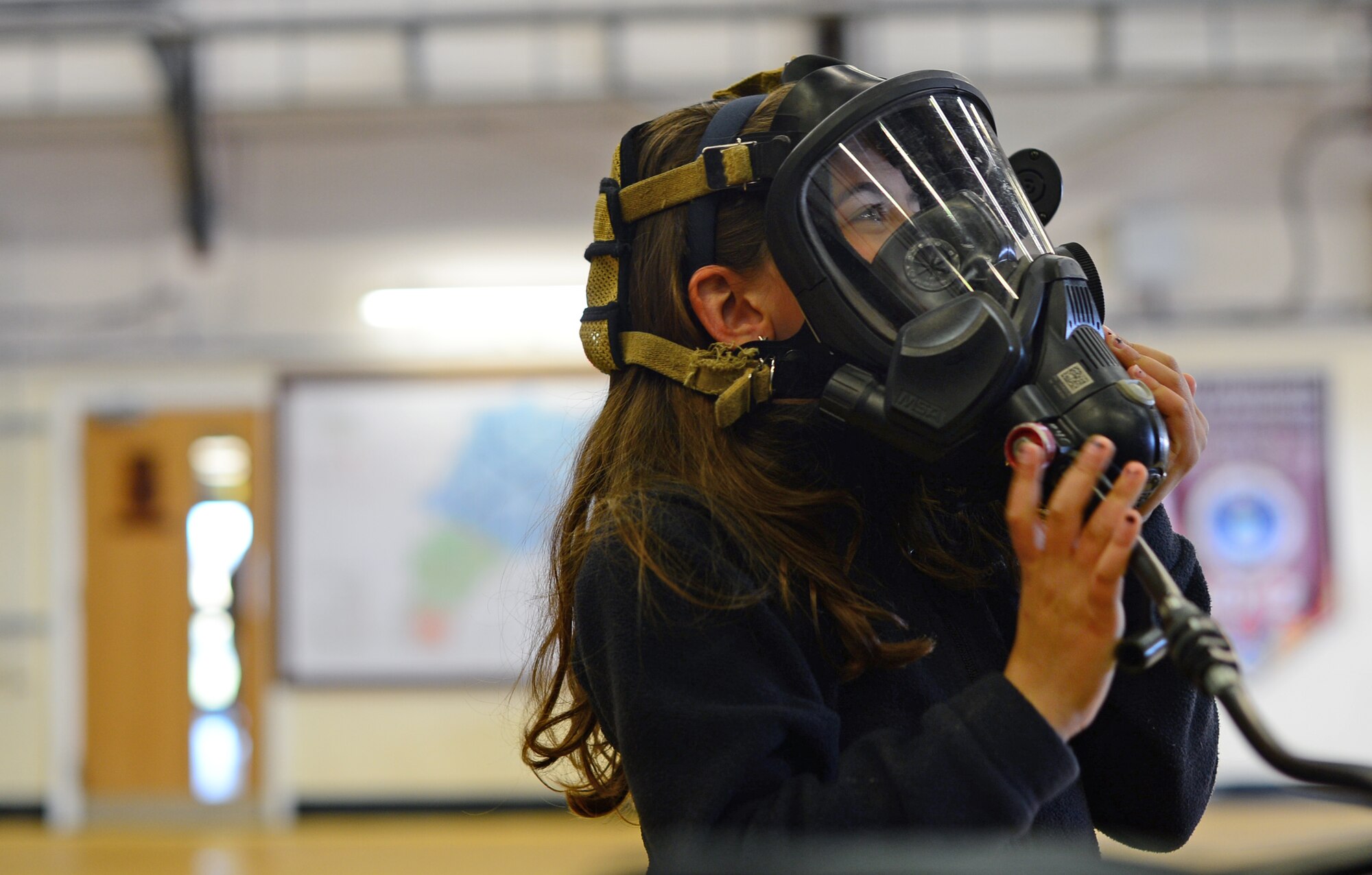 The daughter of a 48th Civil Engineer Squadron firefighter is fitted with a Firehawk self-contained breathing apparatus at the fire station on Royal Air Force Lakenheath, England, May 1, 2015. The fire department hosted family members for an inside look at the roles and duty responsibilities at the station. (U.S. Air Force photo by Senior Airman Erin O’Shea/Released)
