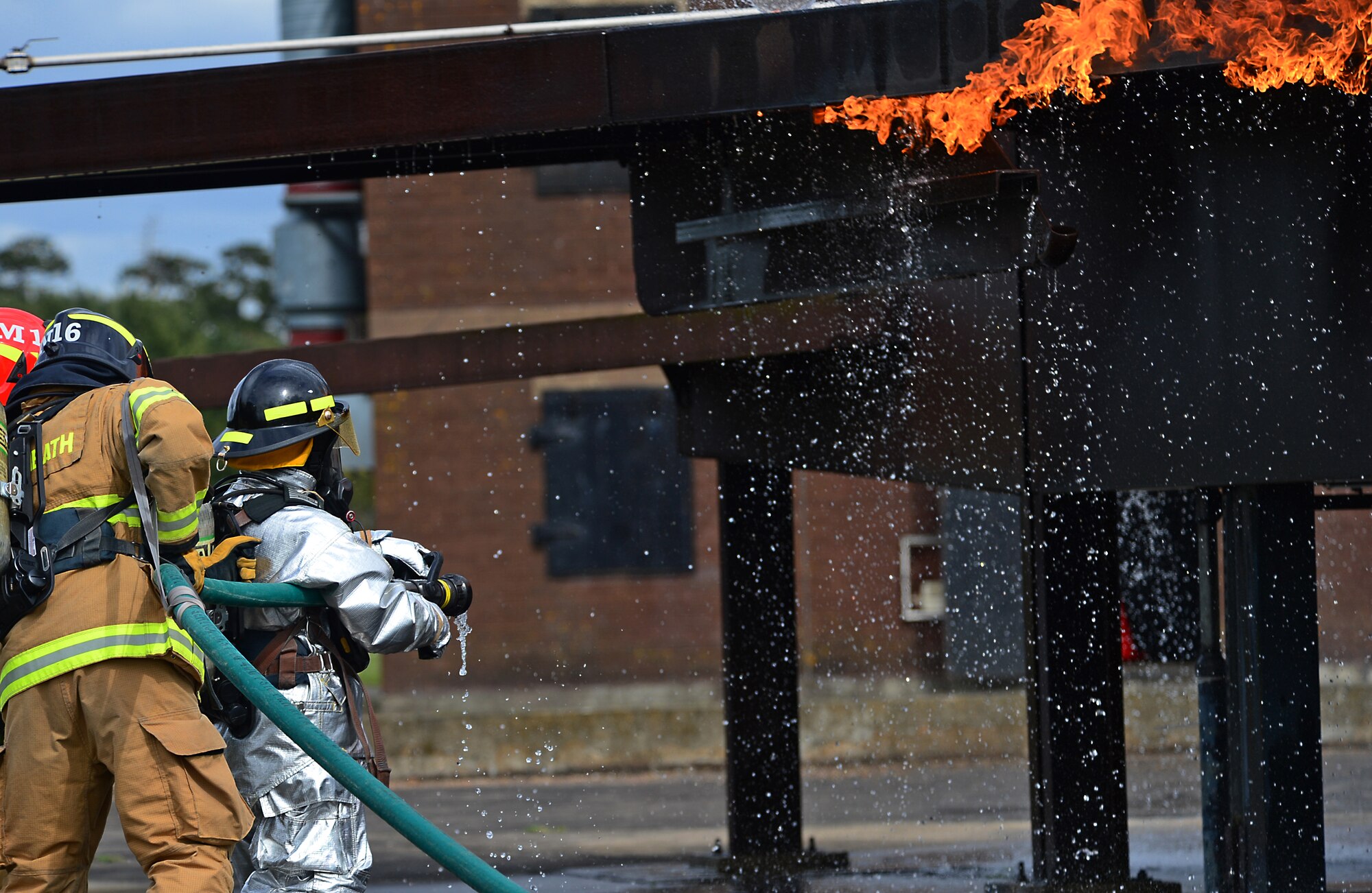 A 48th Civil Engineer Squadron firefighter and his wife (front) extinguish a fire during a spouses’ day at Royal Air Force Lakenheath, England, May 1, 2015. The event served as an opportunity for spouses to gain a better understanding of their partner’s duties and responsibilities at the station. (U.S. Air Force photo by Senior Airman Erin O’Shea/Released)