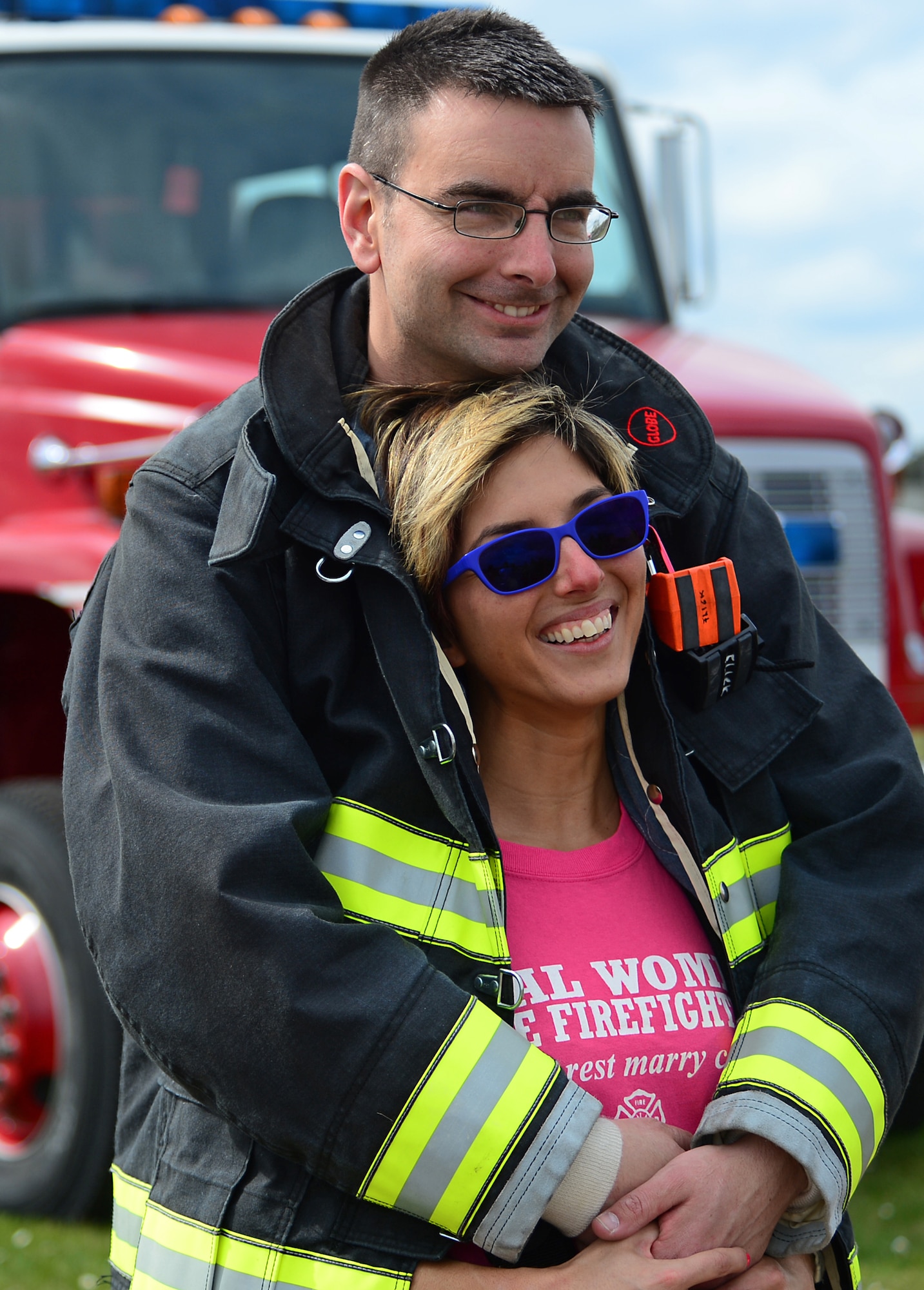 Tech Sgt. Daniele Flick, 48th Civil Engineer Squadron firefighter, hugs his wife, Rosella, after extinguishing a fire together during a spouses’ day event at Royal Air Force Lakenheath, England, May 1, 2015. The event allowed family members to experience hands-on training scenarios and collaborate with other fire department families. (U.S. Air Force photo by Senior Airman Erin O’Shea/Released) 