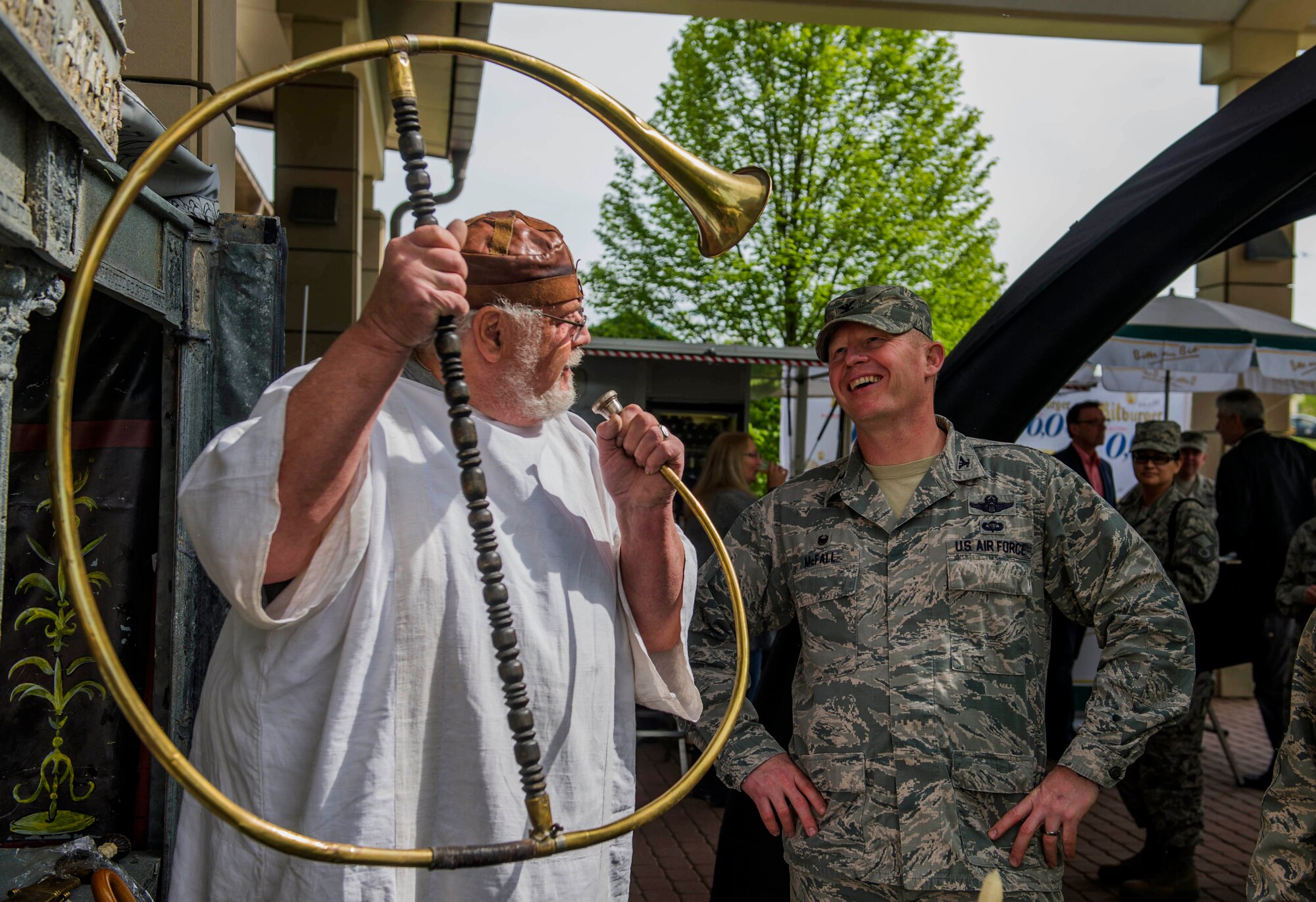 An Explore the Eifel exhibitor, left, showcases a horn to U.S. Air Force Col. Joe McFall, 52nd Fighter Wing commander, right, during the 11th annual Explore the Eifel information and adventure fair at Club Eifel on Spangdahlem Air Base, Germany, April 29, 2015. Booth representatives displayed various aspects of the European culture, ranging from medieval artifact replicas and history, as well as tours, wine-tasting and sky-diving venue. (U.S. Air Force photo by Airman 1st Class Timothy Kim/Released)