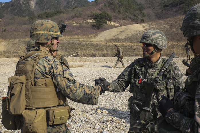 Cpl. Brennan Palmiter shakes hands with a Republic of Korea (ROK) Marine during Korean Marine Exchange Program (KMEP) 15 in the vicinity of Pohang, South Korea March 30, 2015. The 31st Marine Expeditionary Unit (MEU) participated in KMEP 15. The overall objective of KMEPs are to enhance amphibious operations between ROK and U.S. forces that contributes to security and stability on the Korean Peninsula as well as the entire Asia-Pacific region.  The ROK Marines are with 33rd Battalion, 1st ROK Marine Division, and the U.S. Marines are with Company E, Battalion Landing Team 2nd Battalion, 4th Marines, 31st MEU.  (U.S. Marine Corps photo by Cpl. Ryan C. Mains/ Released)