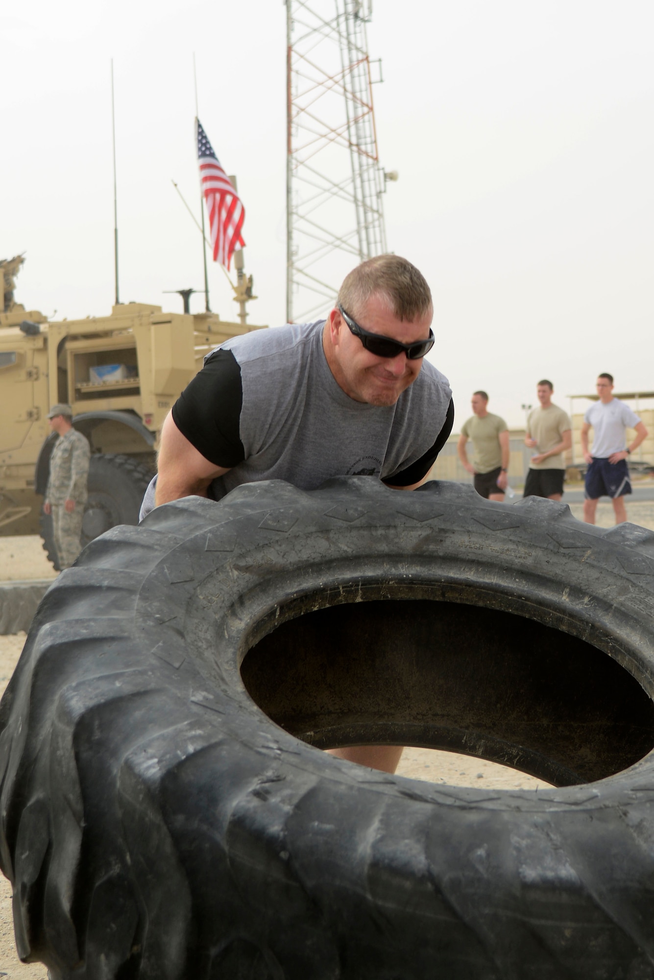 U.S Air Force Master Sgt. Craig Bosse, 386th Force Support Squadron community support flight superintendent, flips a tire during a memorial challenge at an undisclosed location in Southwest Asia May 2, 2015. The 386th Civil Engineer Squadron explosive ordnance disposal members hosted the event to remember the sacrifice Service members made and to raise awareness for the EOD Warrior Foundation, a non-profit organization that honors fallen EOD warriors. (U.S. Air Force photo by Senior Airman Racheal E. Watson/Released)