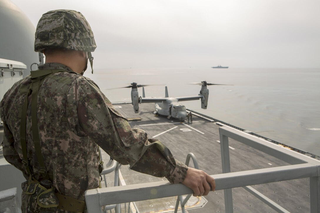 Republic of Korea Marine Corps Lt. Col. Jeong Hyung-Goo watches a U.S. Marine Corps MV-22B Osprey land on the flight deck of the Republic of Korea ship Dokdo (LPH 6111), at sea, March 26, 2015. This was the first time an Osprey has landed on a ROK amphibious assault ship. The aircraft is with Marine Medium Tiltrotor Squadron 262 (Reinforced), 31st Marine Expeditionary Unit. The Marines of the 31st MEU are embarked aboard the forward-deployed amphibious assault ship USS Bonhomme Richard (LHD 6) and are currently participating in Korean Marine Exchange Program 15 during the MEU’s annual Spring Patrol of the Asia-Pacific region. (U.S. Marine Corps photo by SSgt. Joseph DiGirolamo/Released)